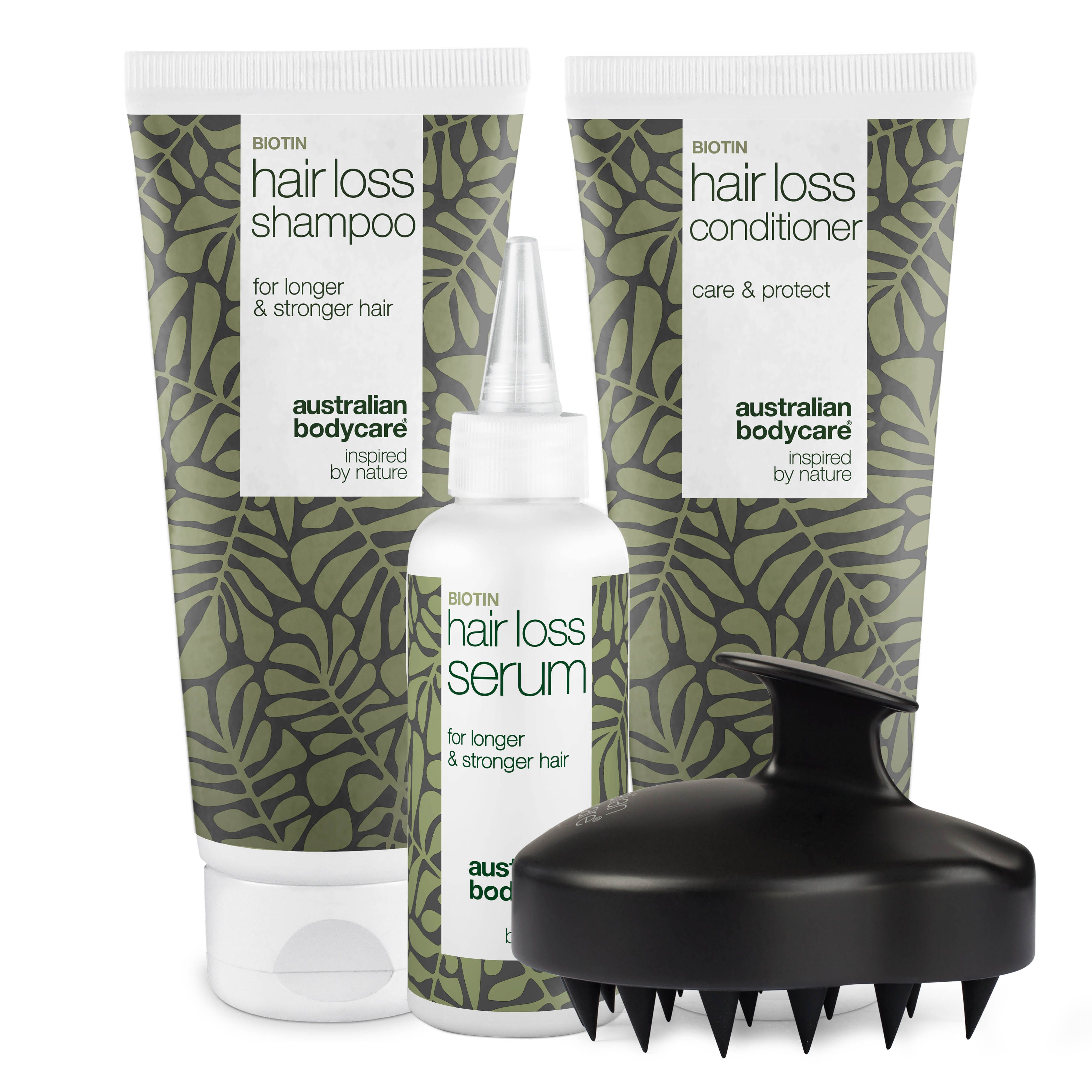Shampoo, Conditioner und Serum gegen Haarausfall. Schwarze Kopfhautbürste. Weiße Tuben und Flasche mit grünen Blättern.