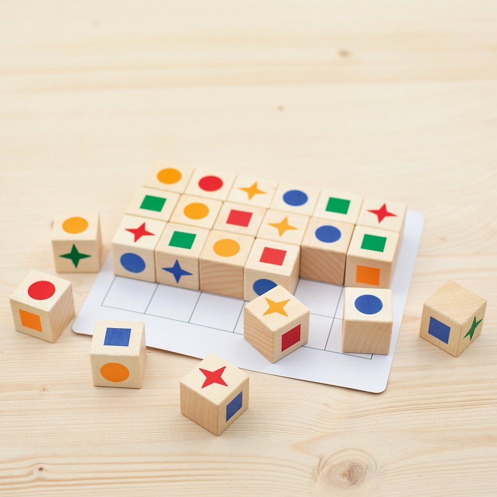 Holzblöcke mit farbigen Formen auf hellem Holz. Spielbrett mit Raster. Mehrere Blöcke und Spielbrett. Draufsicht.