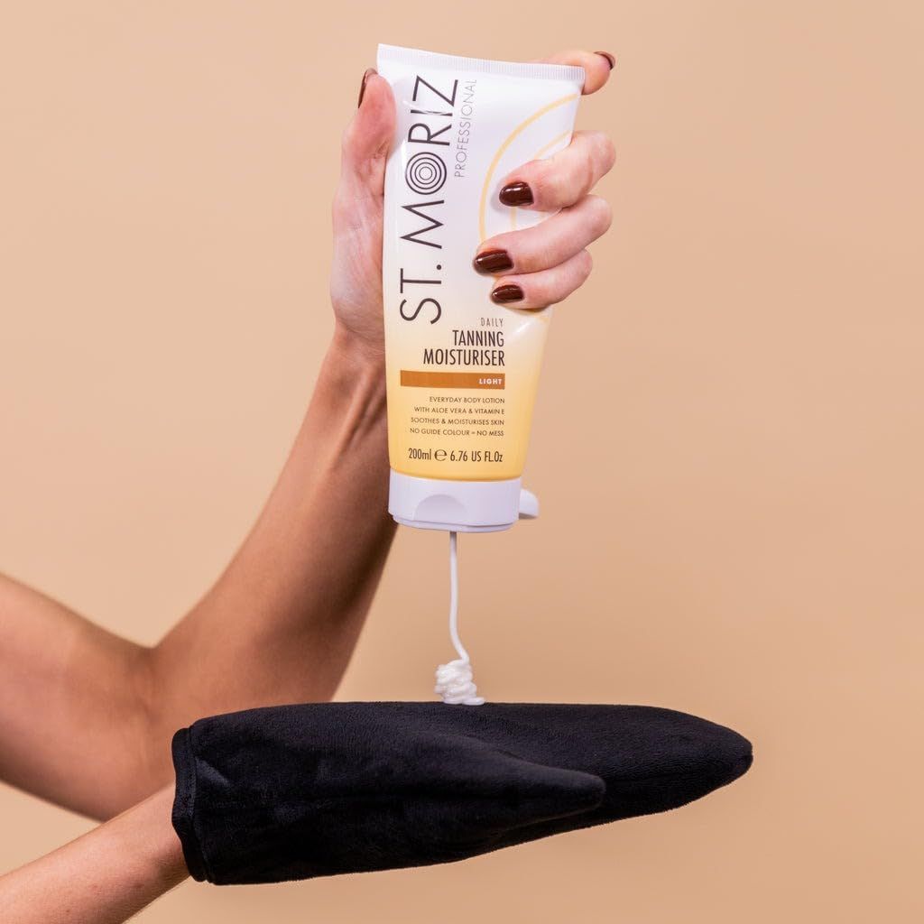 Person hält St. Moriz Lotion. Creme wird auf schwarzen Applikator aufgetragen. Aufschrift: Daily Tanning Moisturiser.