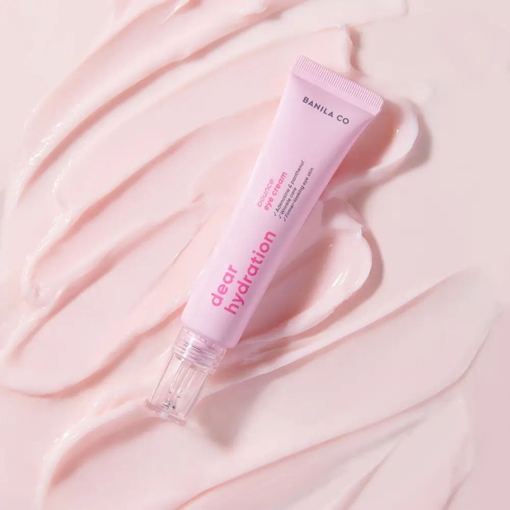 Rosa Tube mit weißer Schrift. Aufschrift: BANILA CO, Dear Hydration, Bounce Eye Cream. Auf rosa Untergrund.