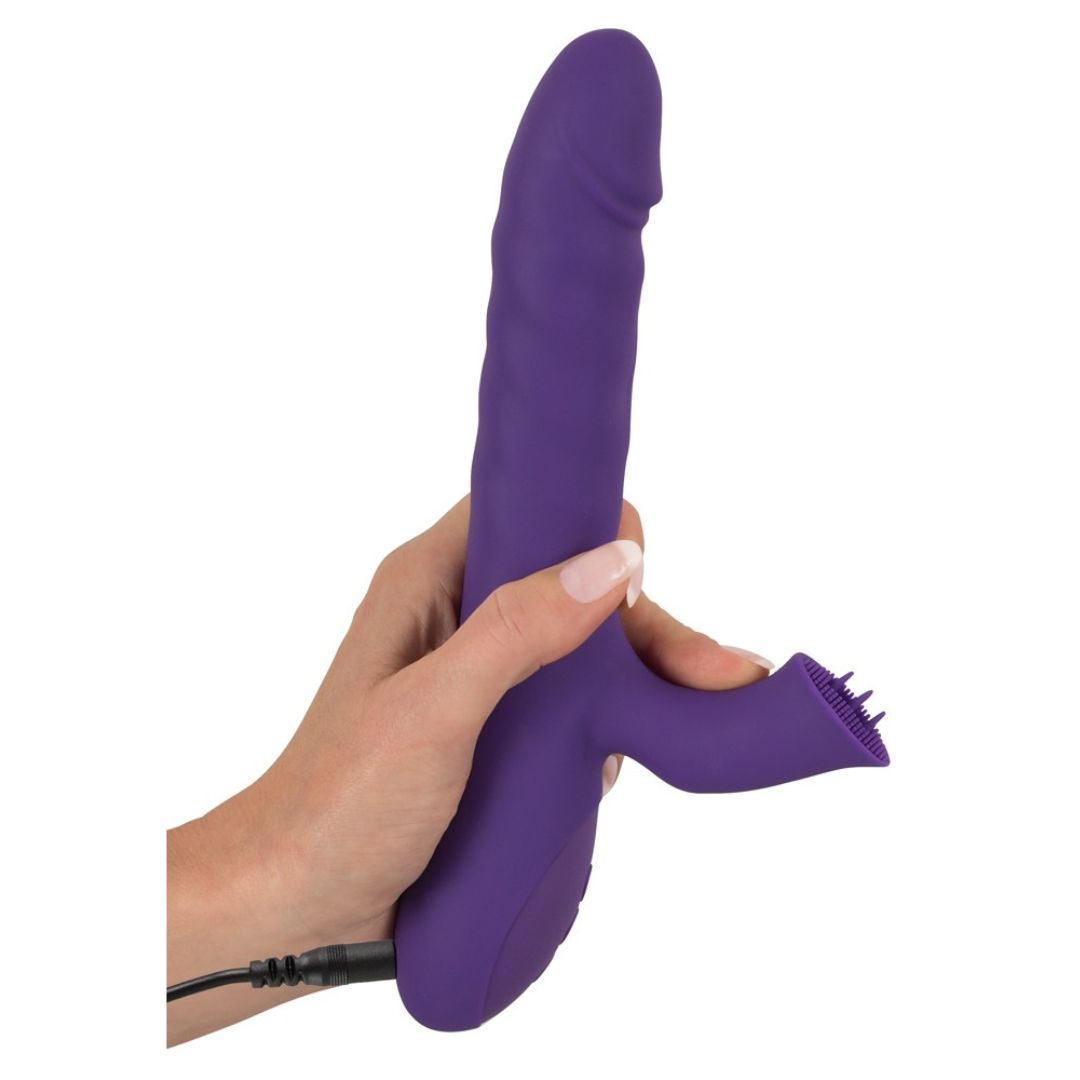 Lila Vibrator, gehalten von einer Hand. Der Vibrator hat eine längliche Form, einen Arm und einen Anschluss für ein Kabel.