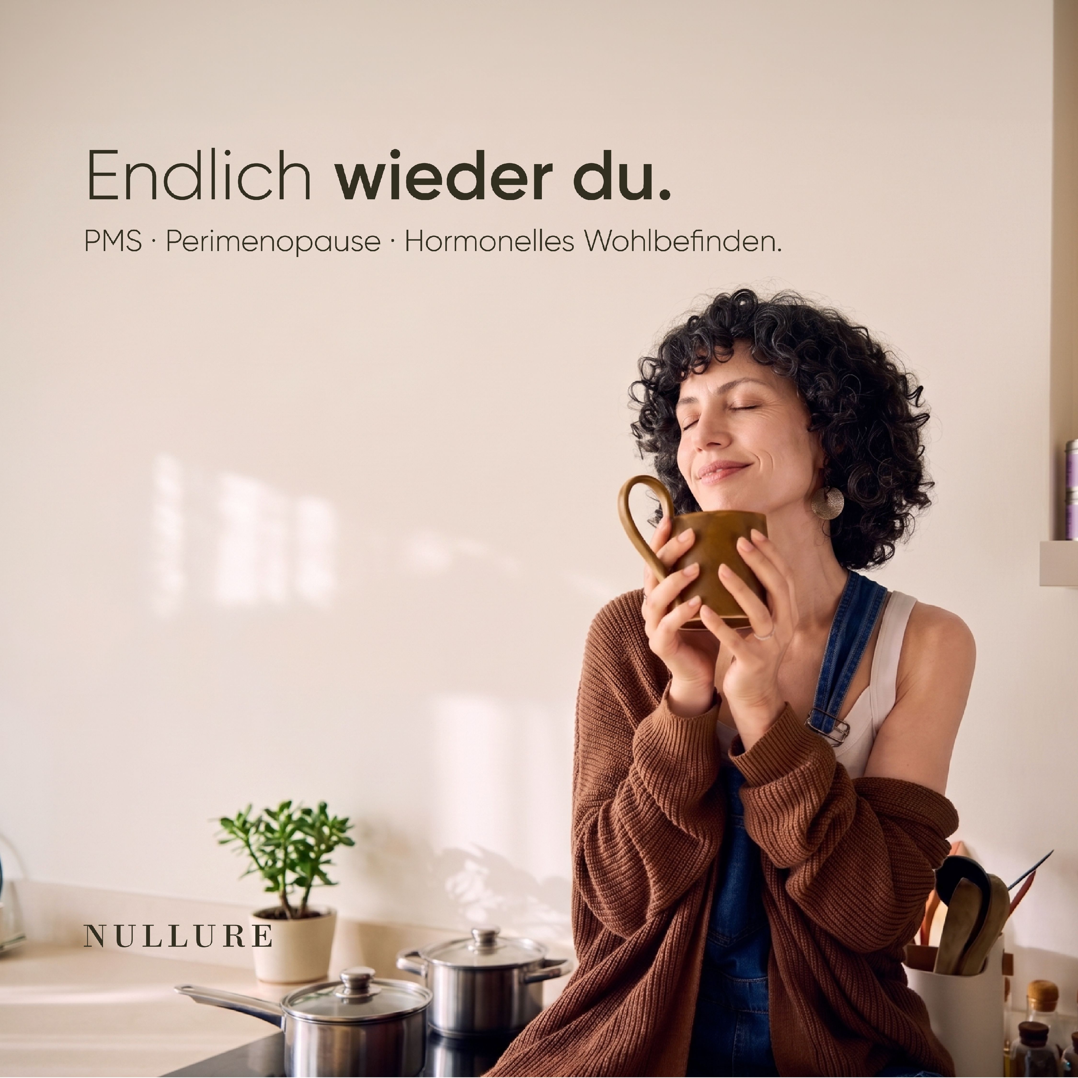 Frau mit geschlossenen Augen hält eine Tasse, umgeben von Küchenutensilien.