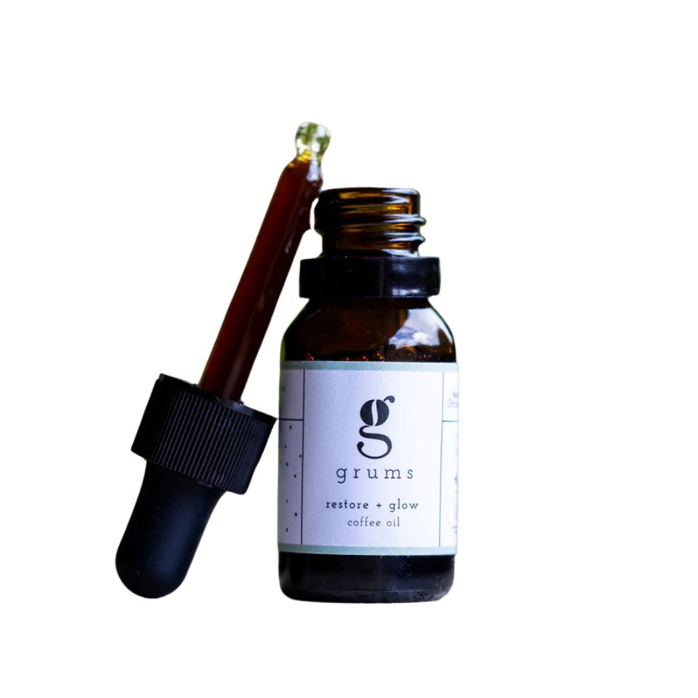 Braune Glasflasche mit schwarzem Deckel und Pipette. Auf dem Etikett steht "grums restore + glow coffee oil".