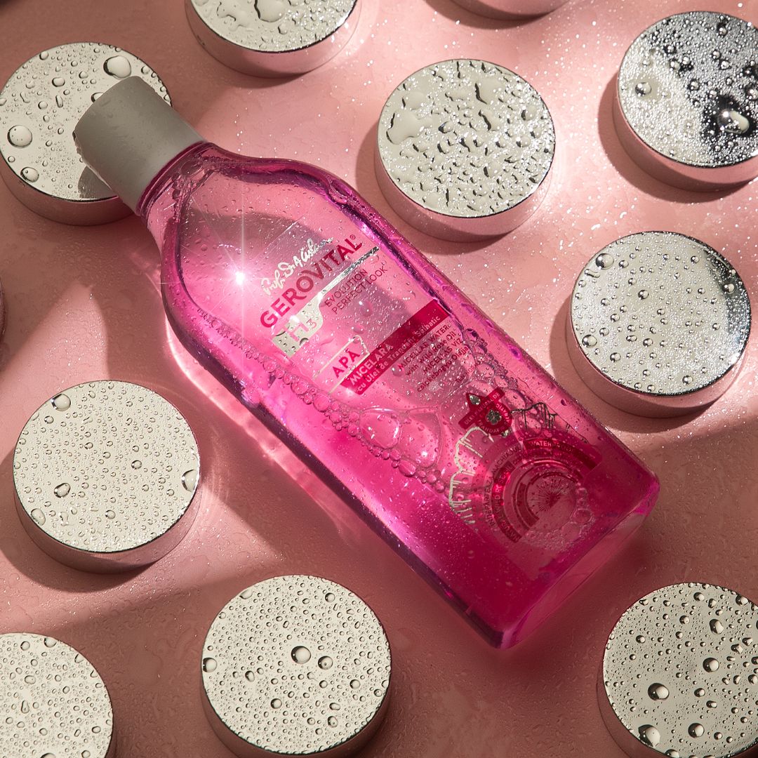 Rosa Flüssigkeit in einer transparenten Flasche mit weißem Deckel. Aufkleber mit Text: Gerovital, Micellare Wasser. Hintergrund: silberne Kreise.