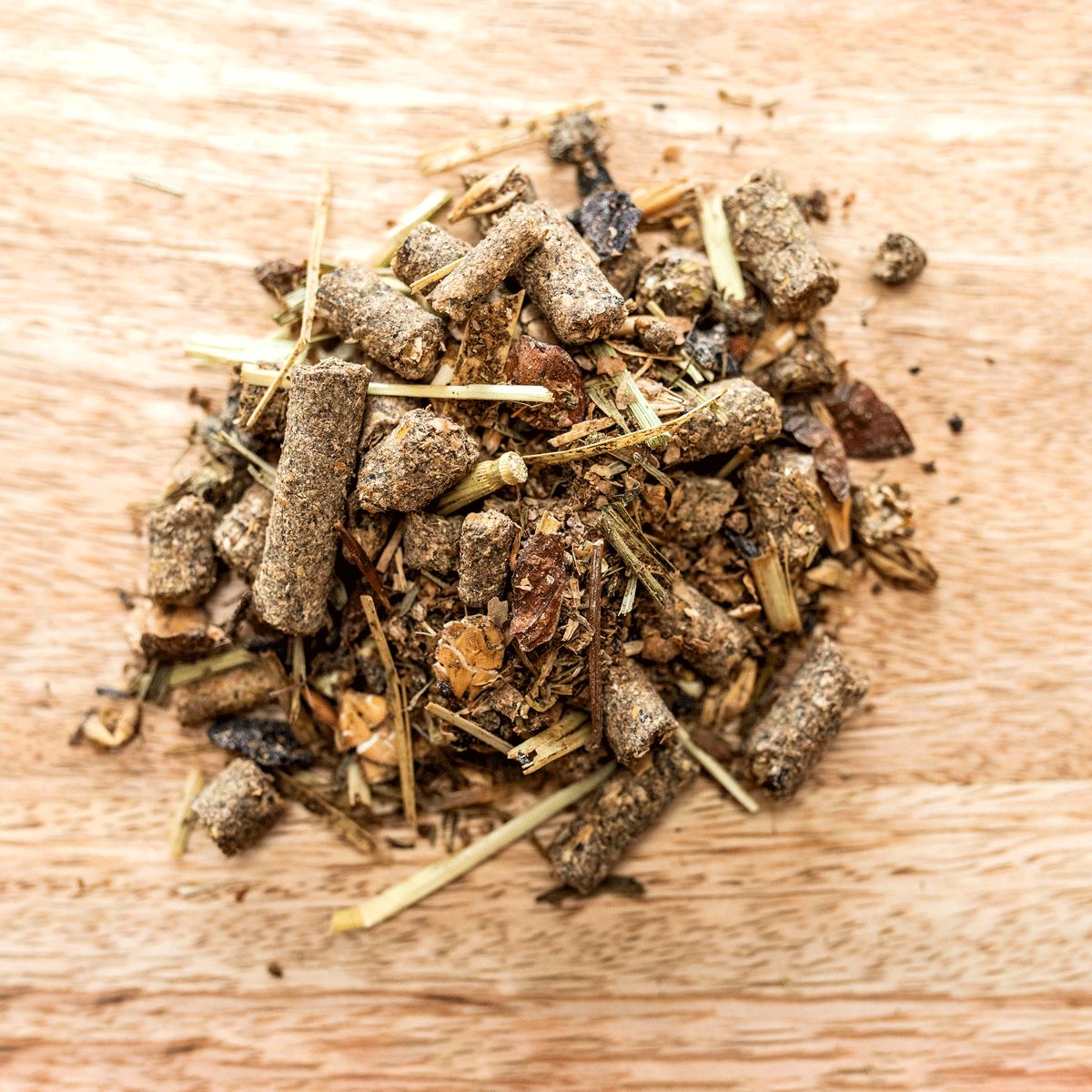 Haufen von St. Hippolyt Hesta Mix light energy auf Holzoberfläche. Verschiedene braune Bestandteile.