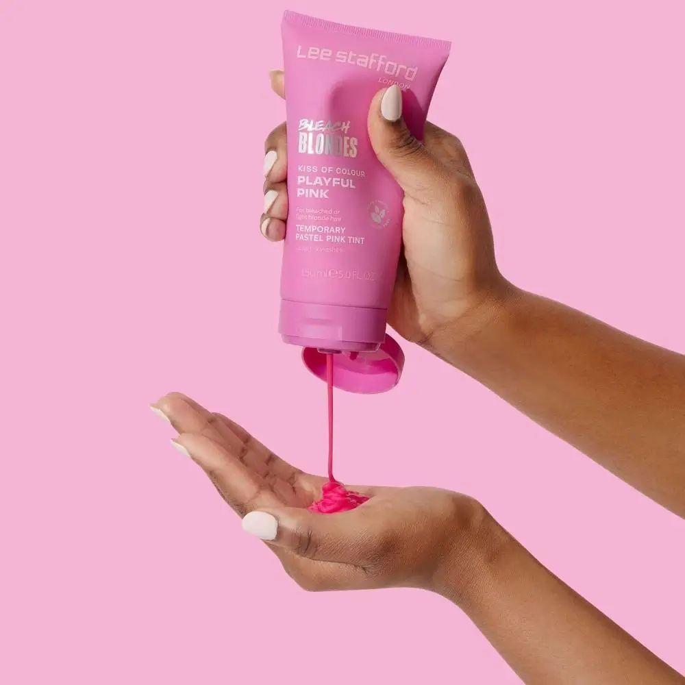 Hände halten rosa Tube, Produkt wird in Handfläche gedrückt. Rosa Flüssigkeit fließt heraus.