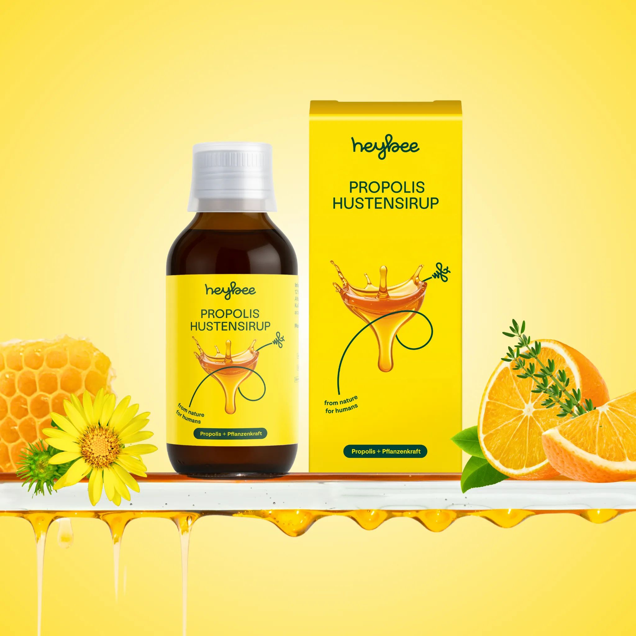 Flasche und Schachtel Heybee Propolis Hustensirup. Honigwabe, Blüte und Orange. Gelber Hintergrund mit Tropfen.