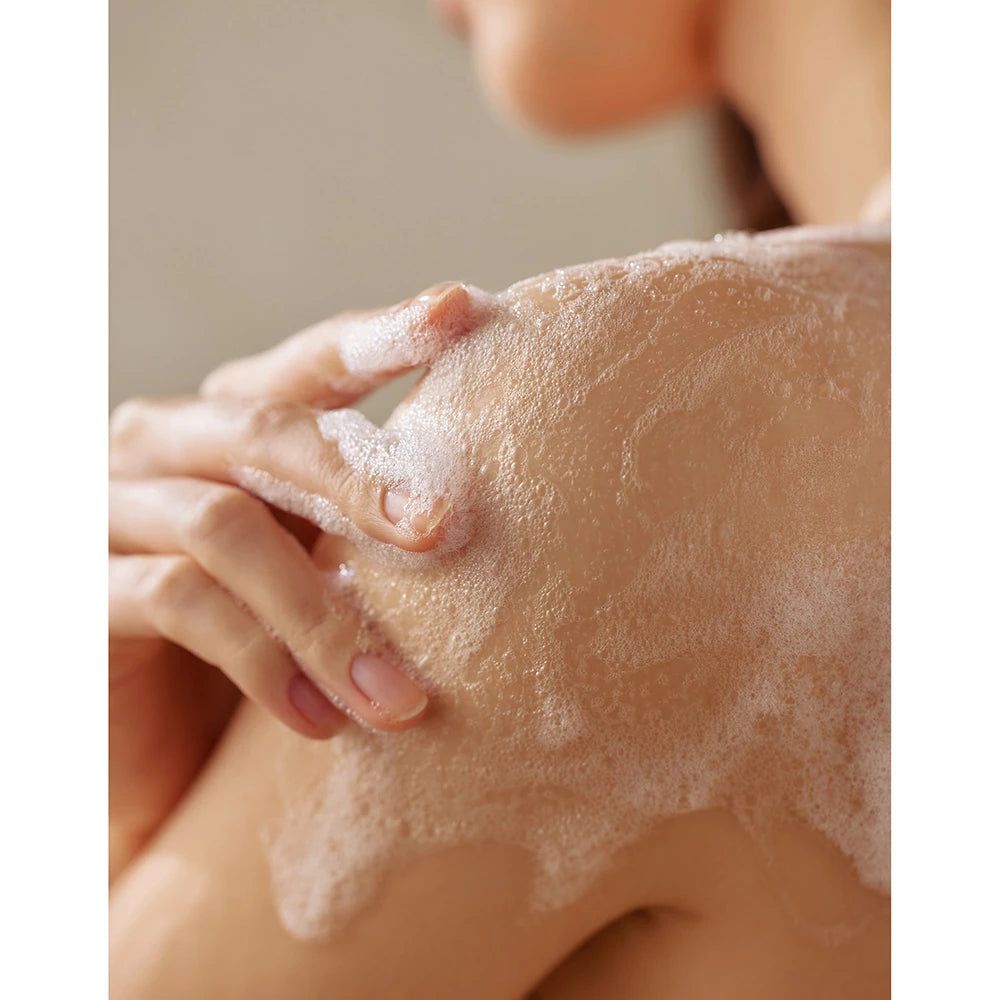 Schulter mit Schaum bedeckt. Helle Haut.