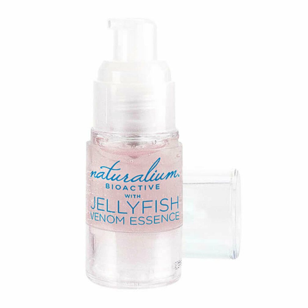 Transparente Flasche mit rosa Flüssigkeit und Pumpe. Produktname und Qualifikationen auf dem Etikett. Offene, transparente Kappe.
