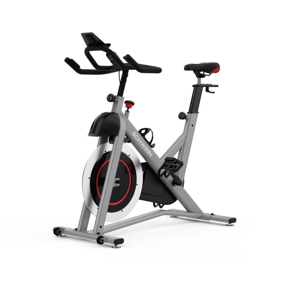Grauer Heimtrainer mit rotem Akzent. Schwarzer Lenker, Sattel und Pedale. Marke: Schwinn. Wasserflaschenhalterung.