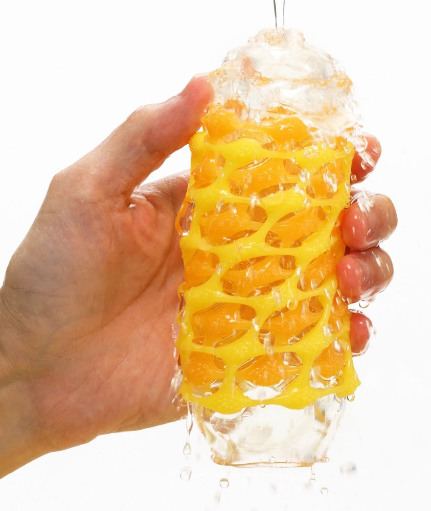 Gelber TENGA ARTE WEAVE Masturbator unter Wasser. Gelbes Gittermuster, transparente Hülle.