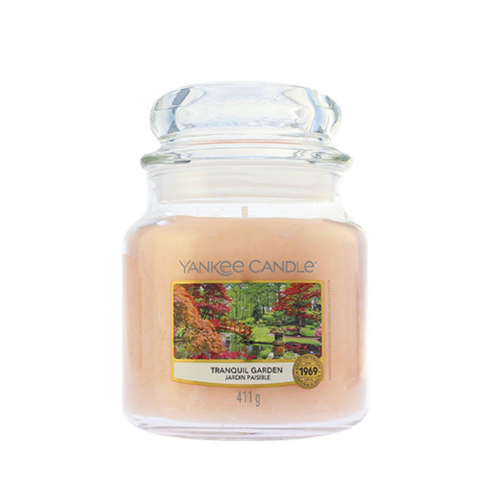 Duftkerze im Glas mit Deckel. Etikett mit Landschaftsmotiv und Aufschrift "Tranquil Garden". Marke: Yankee Candle. Gewicht: 411g.