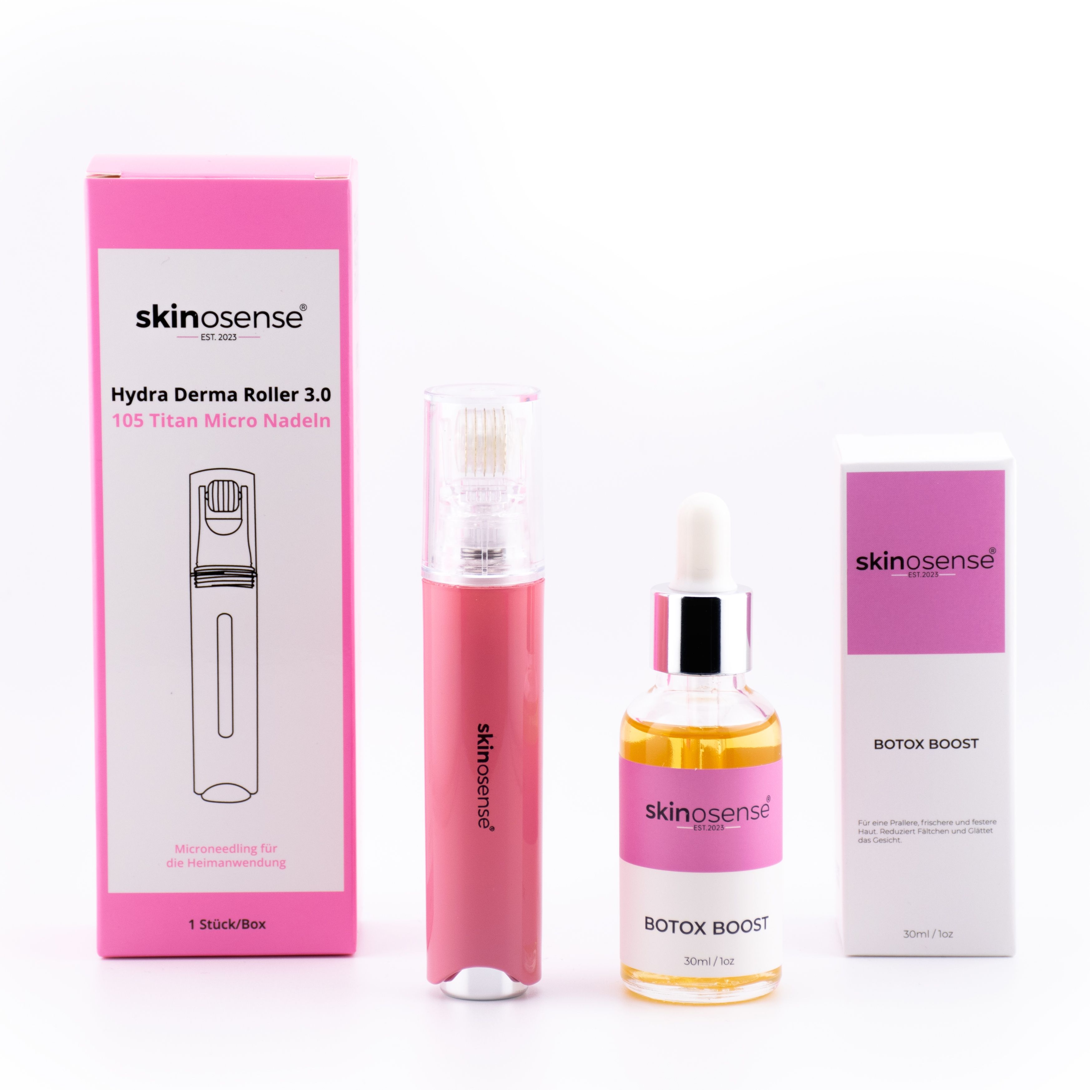 Set mit pinkfarbener Verpackung. Enthält Derma Roller, Serumflasche und zwei Schachteln mit Produktnamen.