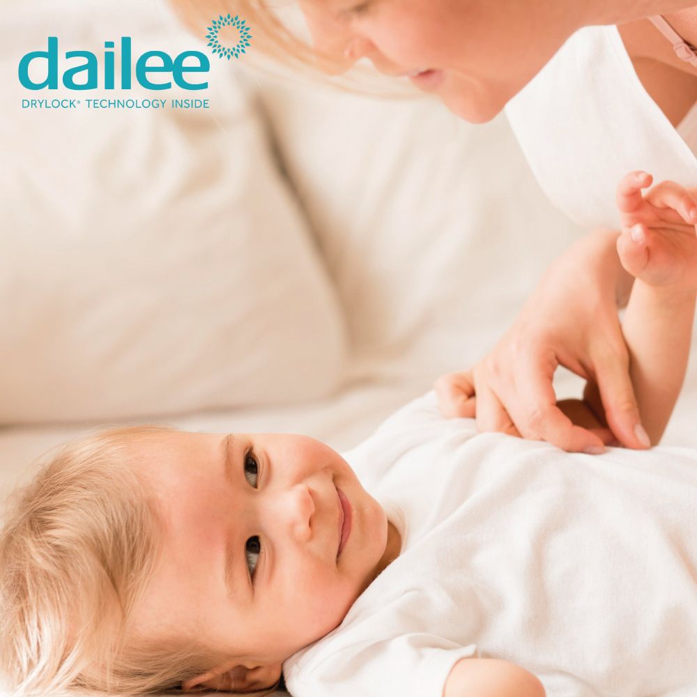 Ein Baby liegt auf dem Bett, eine Hand berührt es. Dailee Logo.