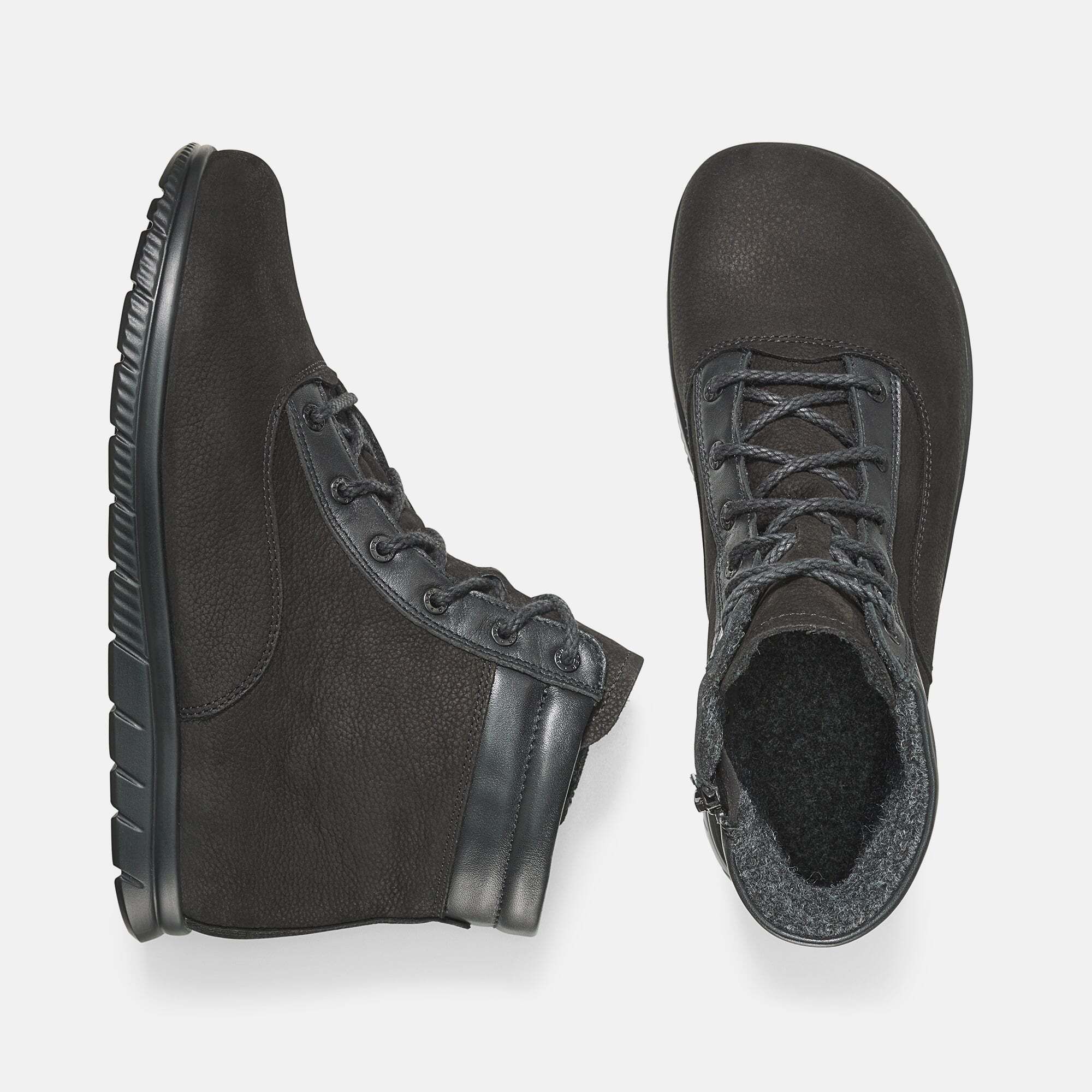 Zwei schwarze Stiefeletten. Eine von oben, eine von der Seite. Schnürung, Leder, breite Sohle.