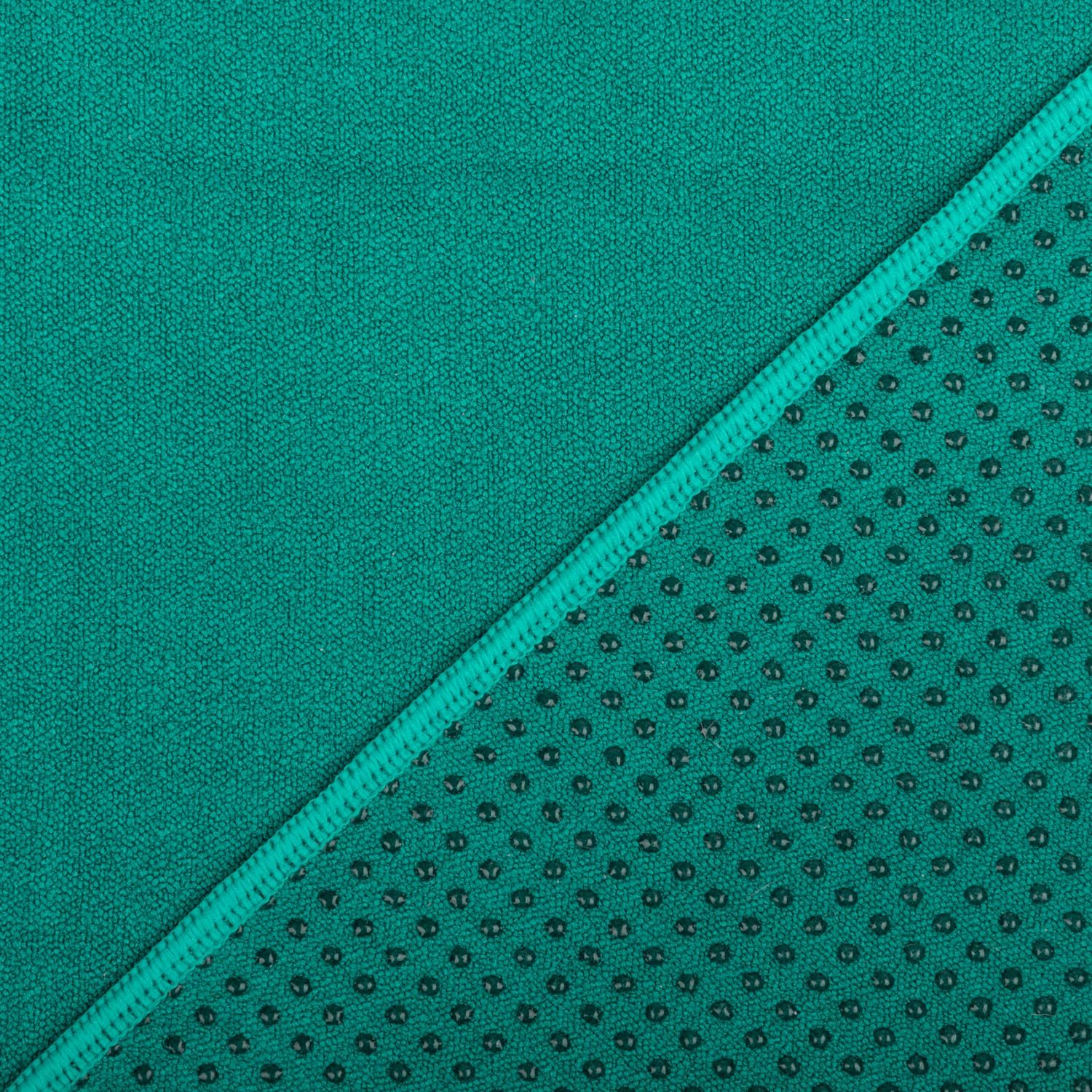 Grünes Yogahandtuch, diagonal geteilt. Eine Seite glatt, andere mit Noppen. Naht in Grün.