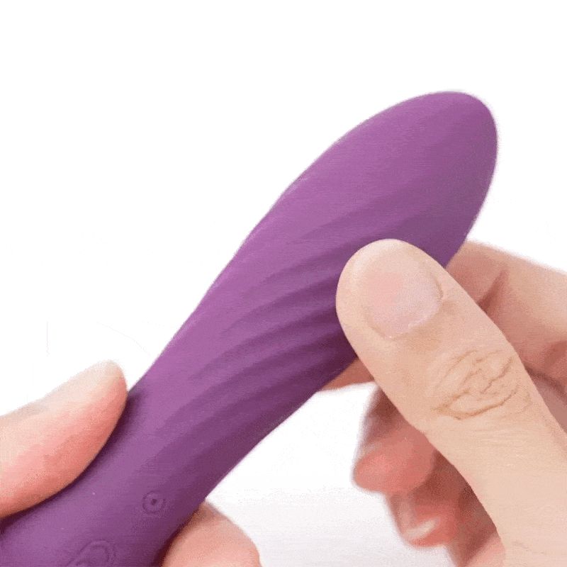 Lila Vibrator mit gewellter Oberfläche. Eine Hand hält das Produkt.