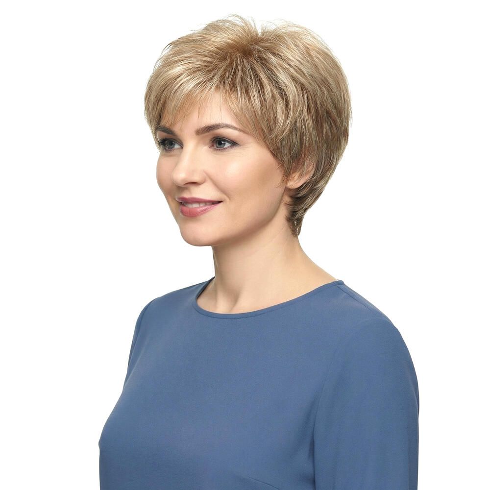 Kurzhaarperücke in Blondtönen. Seitenansicht einer Frau mit blauer Bluse. Die Perücke hat einen kurzen, fransigen Schnitt.