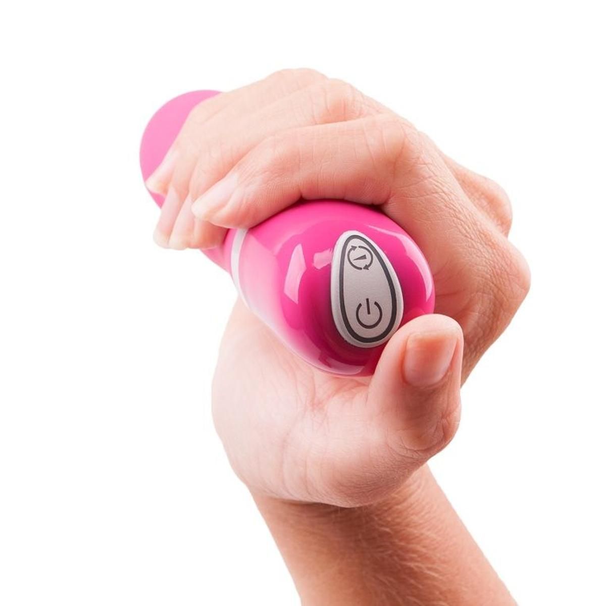 Pinkfarbener Minivibrator in einer Hand gehalten. Bedienfeld mit Ein/Aus-Symbol. Auf weißem Hintergrund.