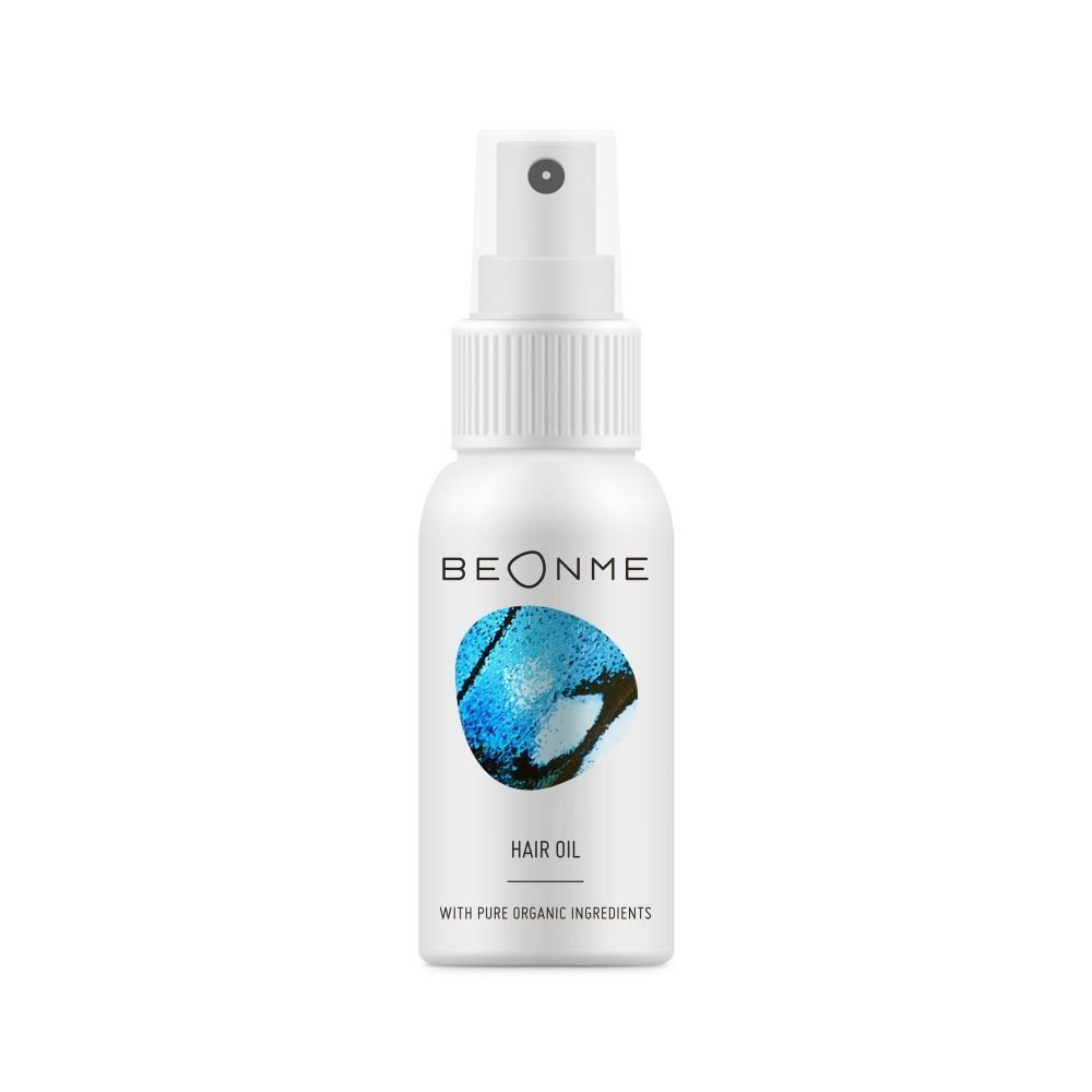 Weiße Sprühflasche mit blauem Schmetterlingsmuster. Aufschrift: BEONME, HAIR OIL, WITH PURE ORGANIC INGREDIENTS.