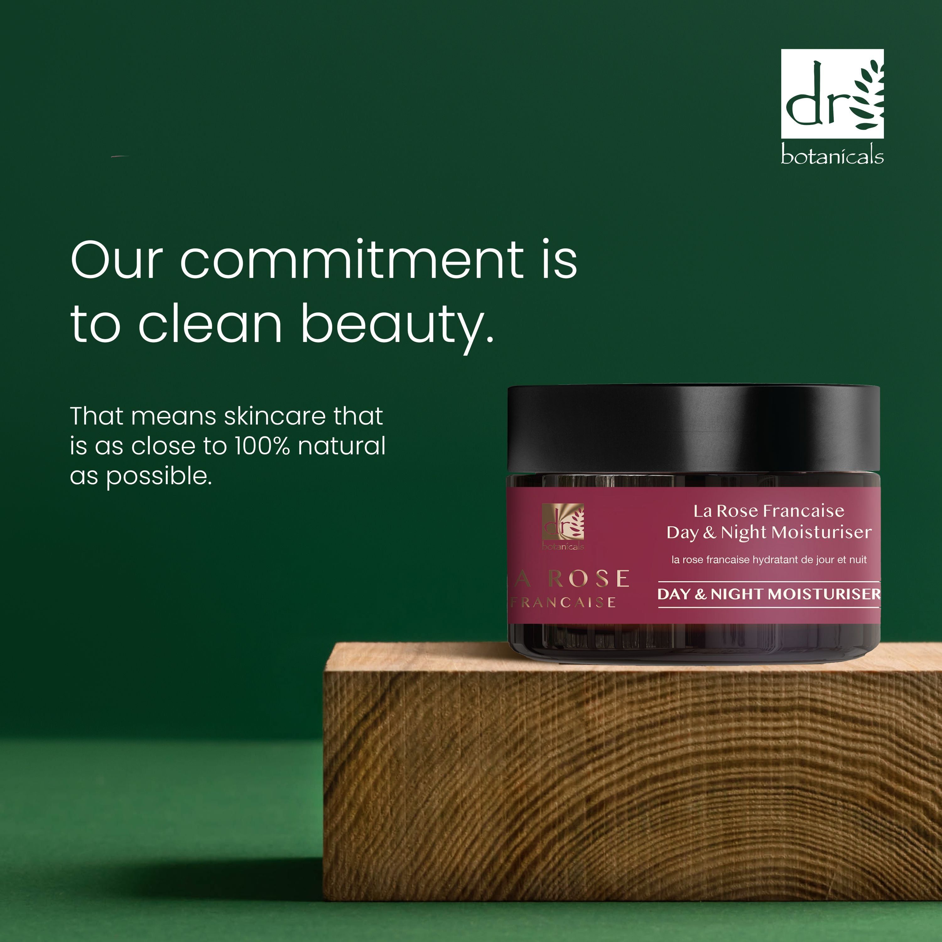 Dunkelrotes Produkt mit schwarzem Deckel auf Holzblock. Aufschrift: La Rose Française Day & Night Moisturiser. Text: Clean Beauty.
