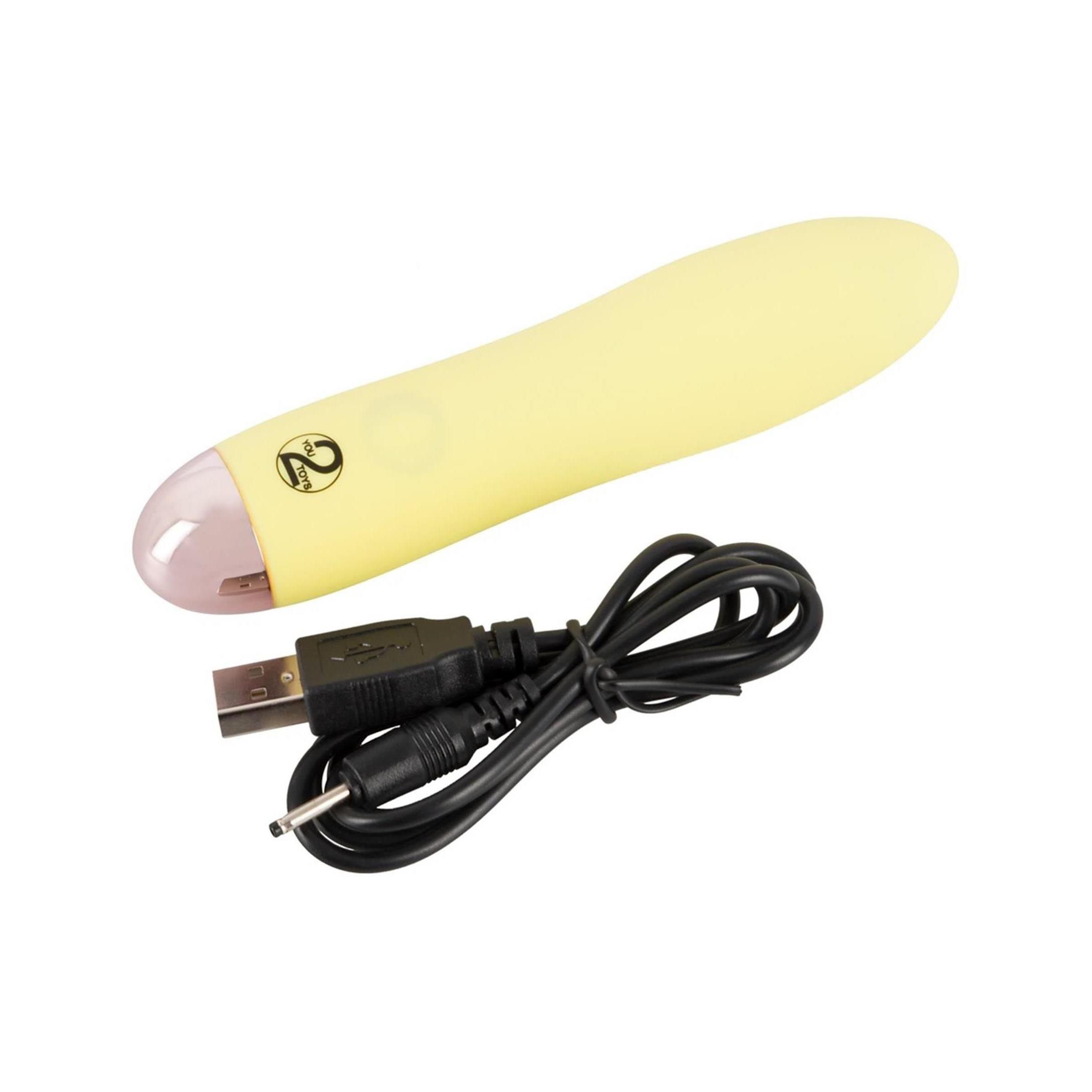 Gelber Vibrator mit USB-Kabel. Rosa Spitze, glatte Oberfläche.