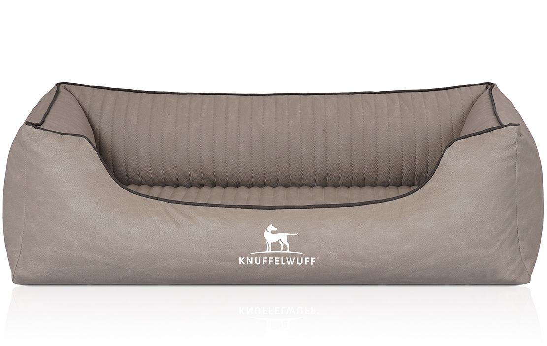 Orthopädisches Hundebett Columbia, beige. Rechteckige Form mit erhöhten Seiten. Schwarze Paspelierung. Logo Knuffelwuff.