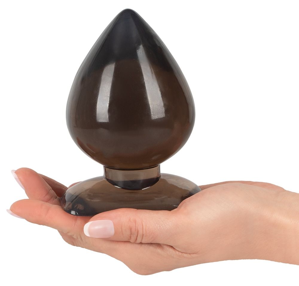 Analplug, braun getönt, Tropfenform. Spitze und Basis dunkler. Glatte Oberfläche. In Hand gehalten. Breiter Basis.
