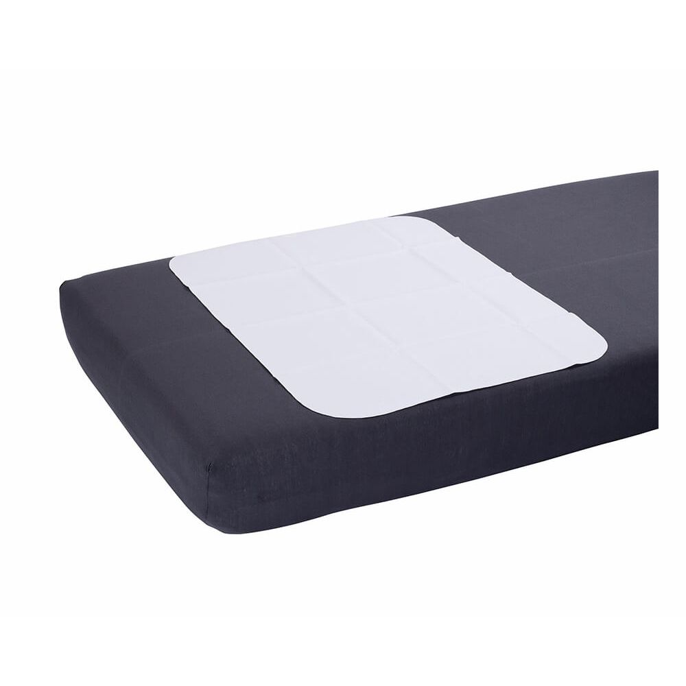 Weiße, rechteckige Bettschutzunterlage auf dunkler Matratze. Molton-Oberfläche, PVC-Unterseite. Eckige Form.