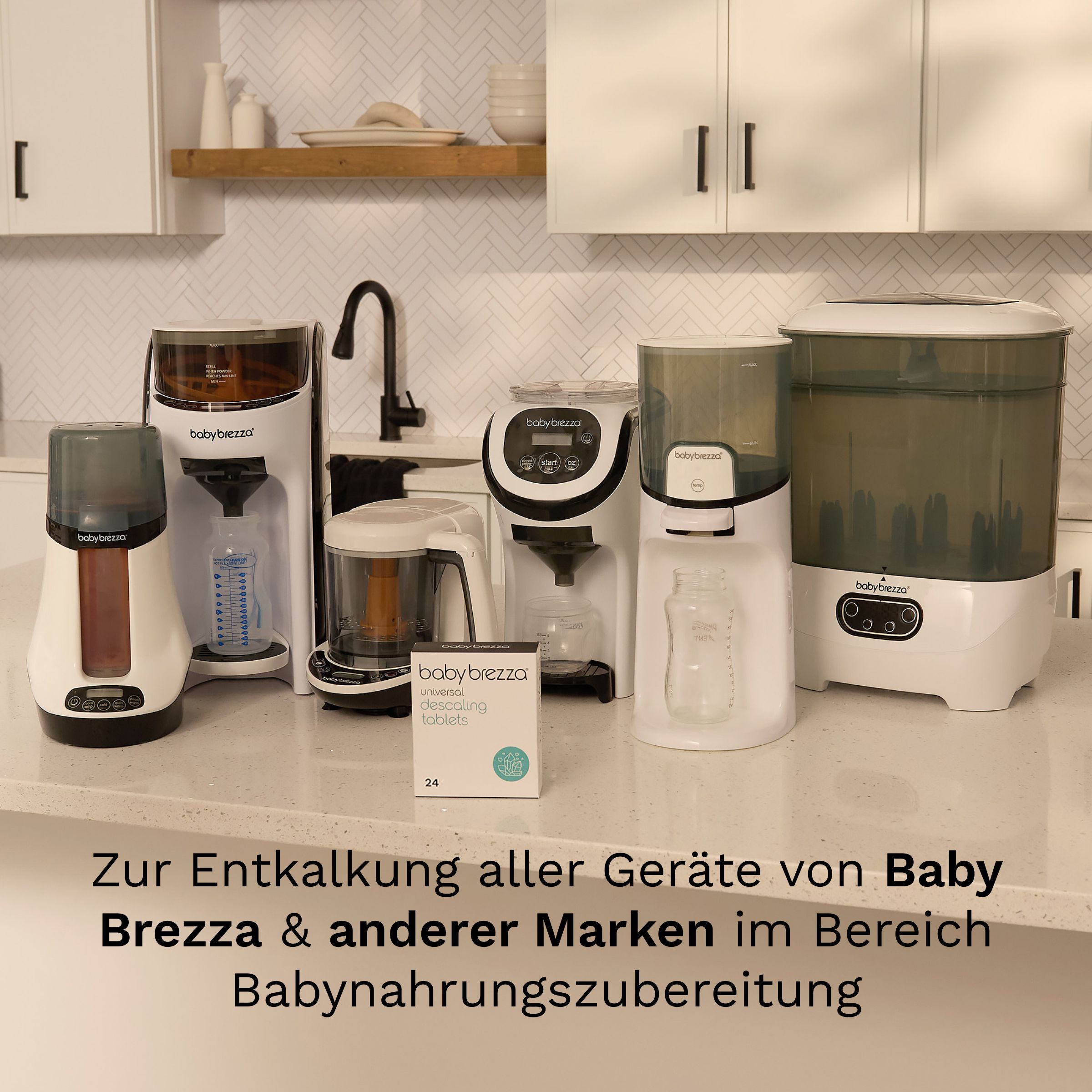 Mehrere Baby Brezza Geräte auf einer Küchenzeile. Eine Packung Universal-Entkalkungstabletten steht davor.