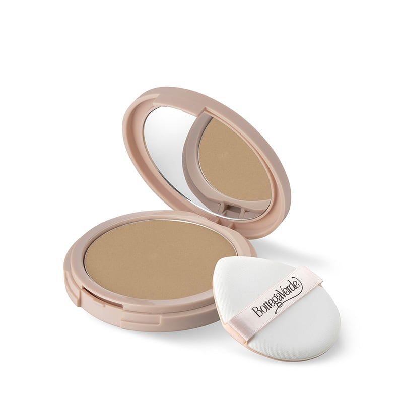 Bottega Verde d'Amore d'Accordo - Fondotinta compatto wet & dry. Un compatto rosa chiaro aperto, con specchio. Accanto, una spugnetta bianca con il nome del marchio. La polvere è di colore beige.
