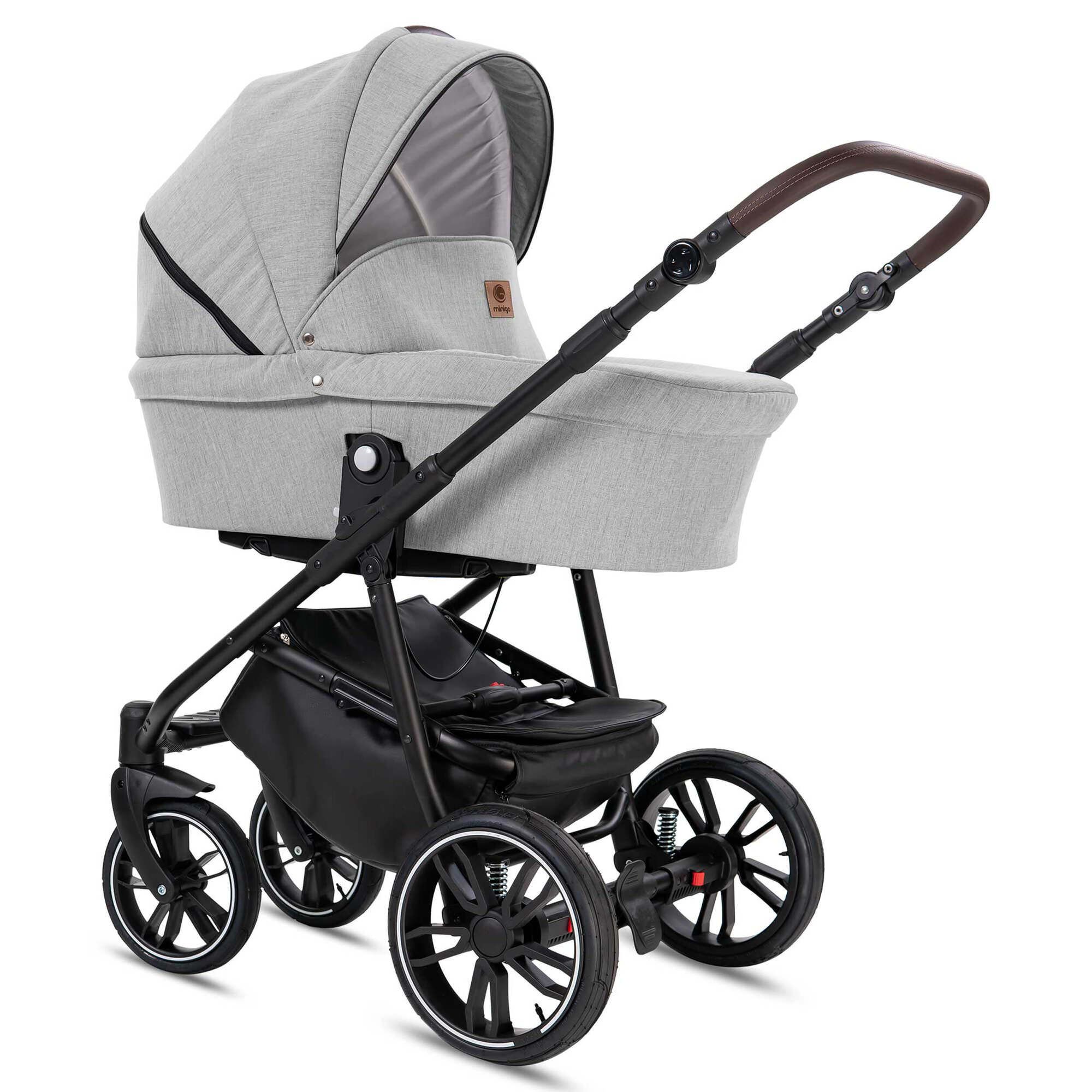 Grauer Kombikinderwagen. Schwarzes Gestell, schwarz-weiße Räder. Babywanne mit Sonnenverdeck. Brauner Griff.