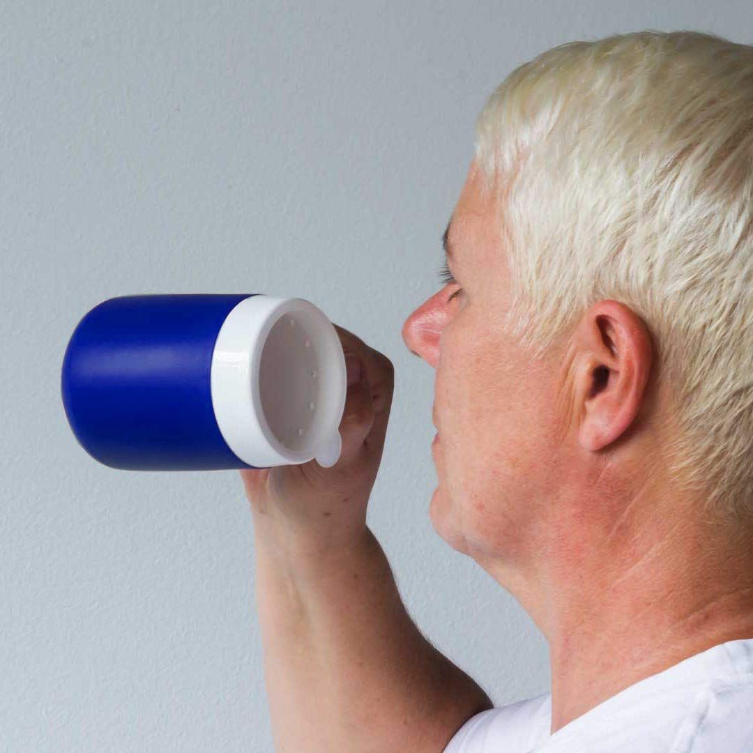 Person trinkt aus einem blauen Becher mit weißem Trinkaufsatz. Der Becher wird horizontal gehalten.