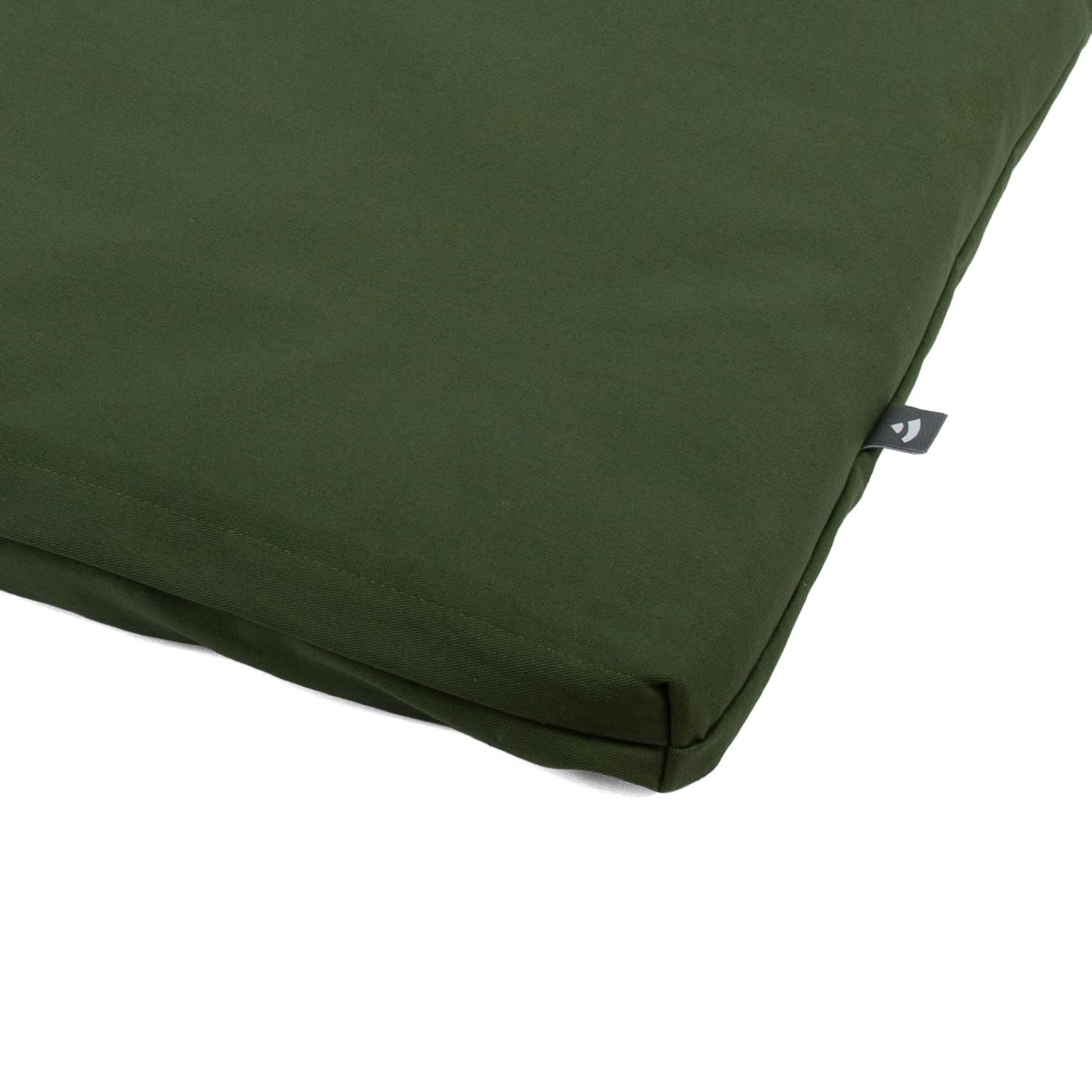 Dunkelgrüne Meditationsmatte aus Stoff mit kleinem Logo-Etikett.