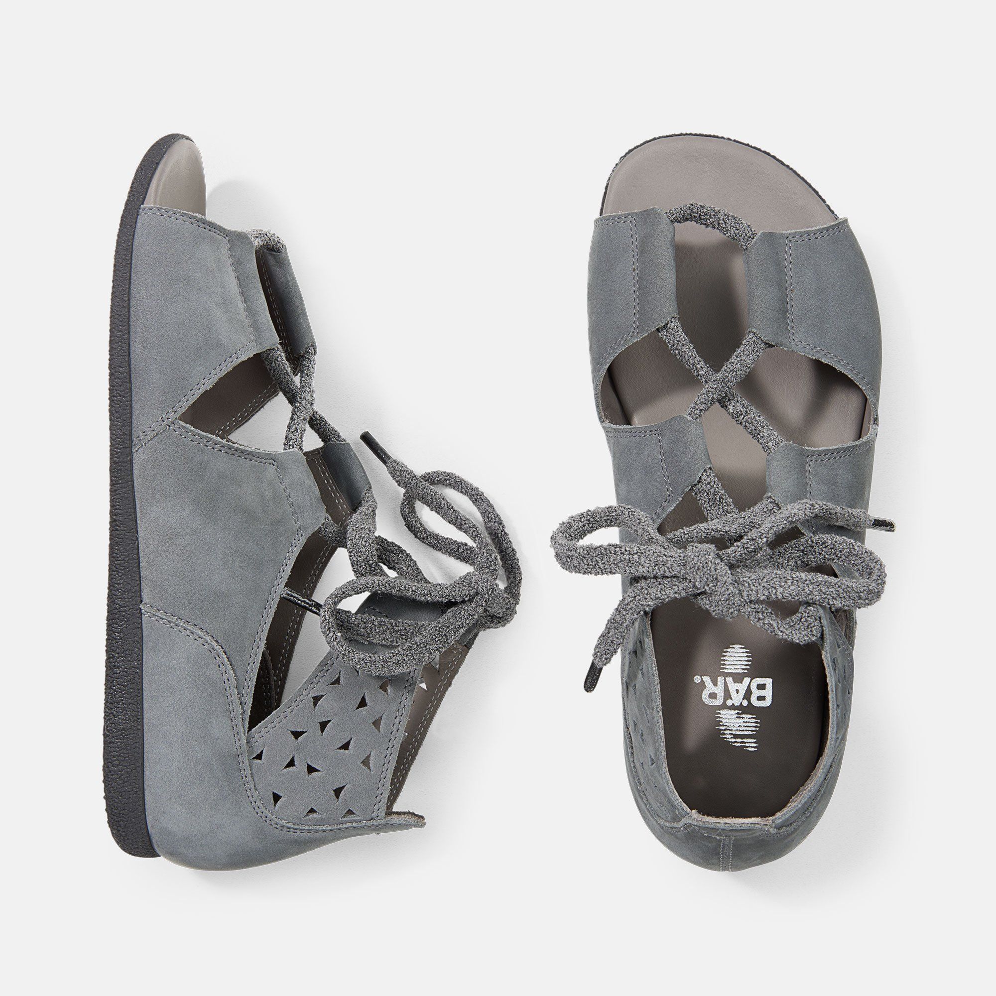 Graue Sandalen, Draufsicht. Schnürung, offene Zehen, seitliche Aussparungen. Sohle mit Logo.