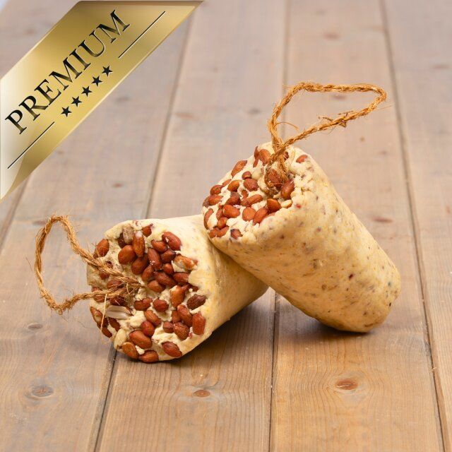 Zwei Fettriegel mit Erdnüssen auf Holz. Goldene Plakette 'Premium'.