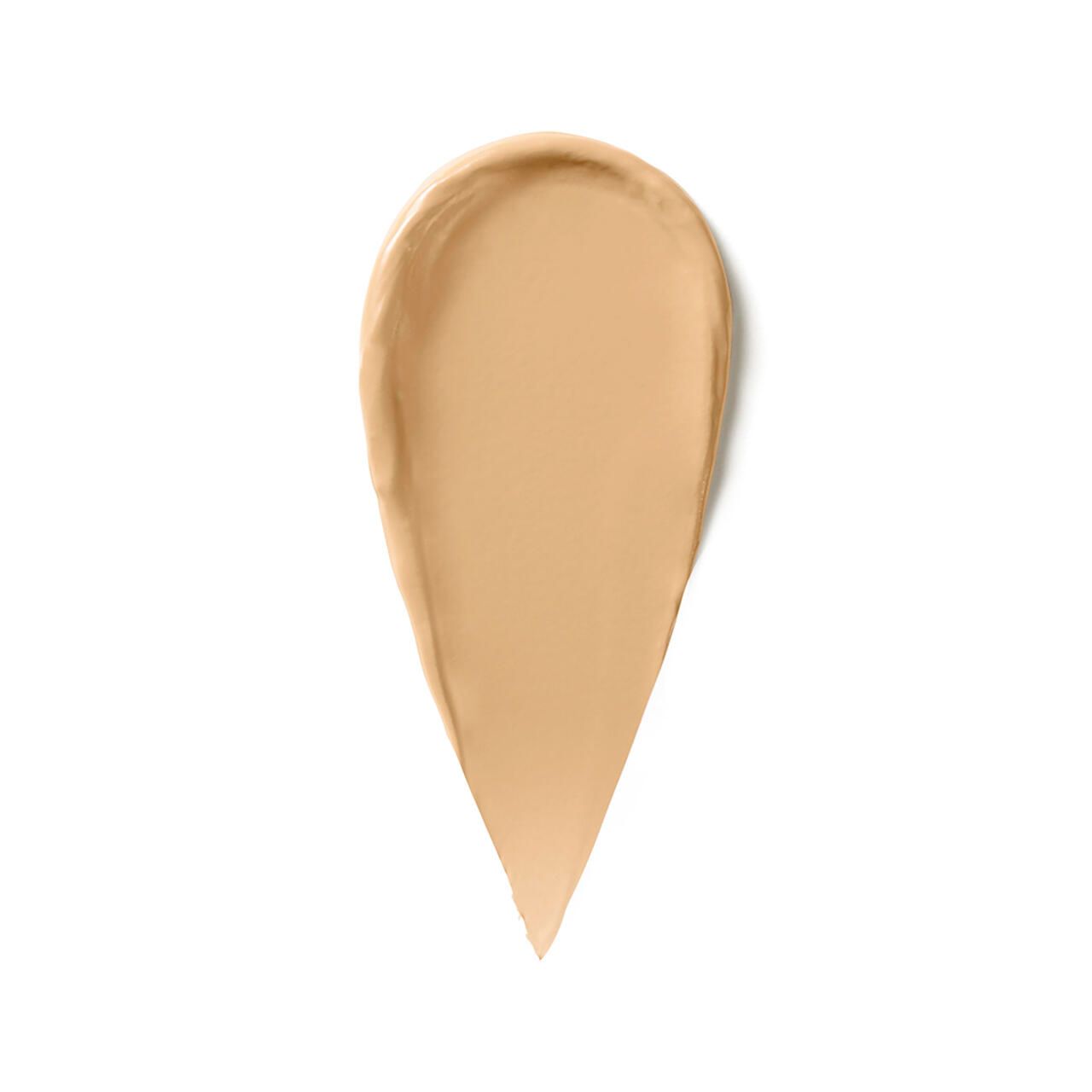 Beigefarbener Concealer-Abstrich in Tropfenform auf weißem Hintergrund.