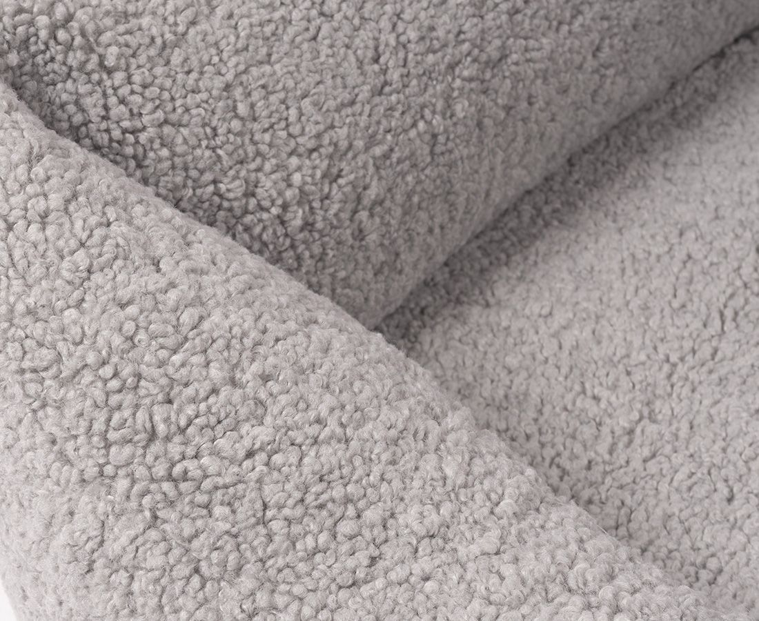 Nahaufnahme des grauen, flauschigen Materials eines orthopädischen Hundebetts. Strukturierte Oberfläche.