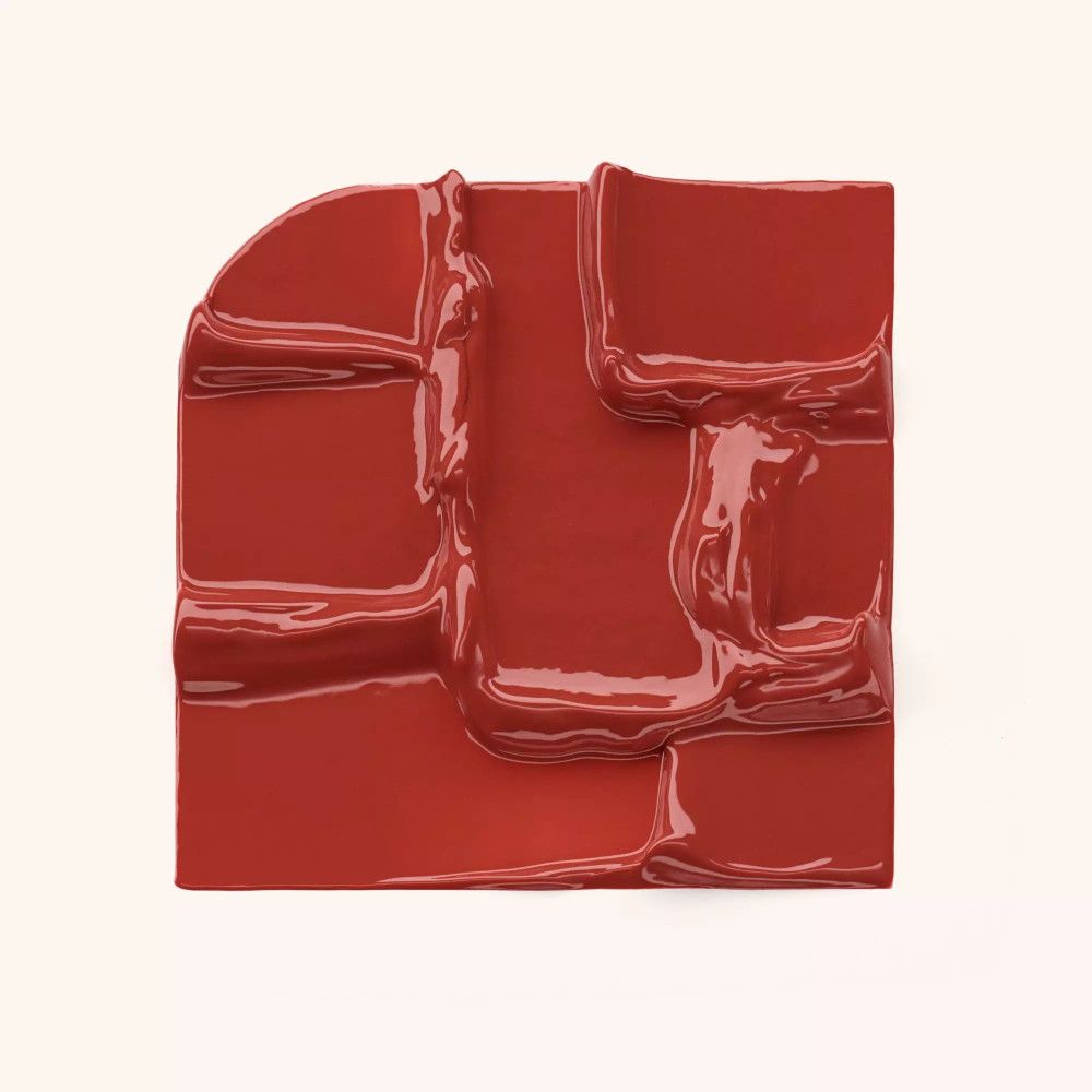 Quadratische Anordnung aus roter, flüssiger Substanz. Oberfläche mit unregelmäßigen Strukturen.