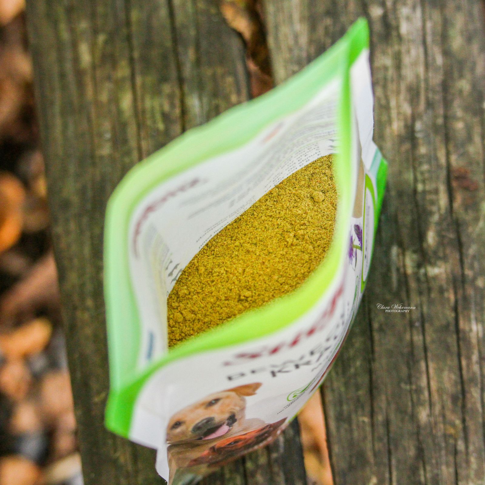 Geöffnete Verpackung von Stiefel Bewegungskräuter. Grün-weiße Verpackung mit Kräutermischung. Auf Holzuntergrund platziert.