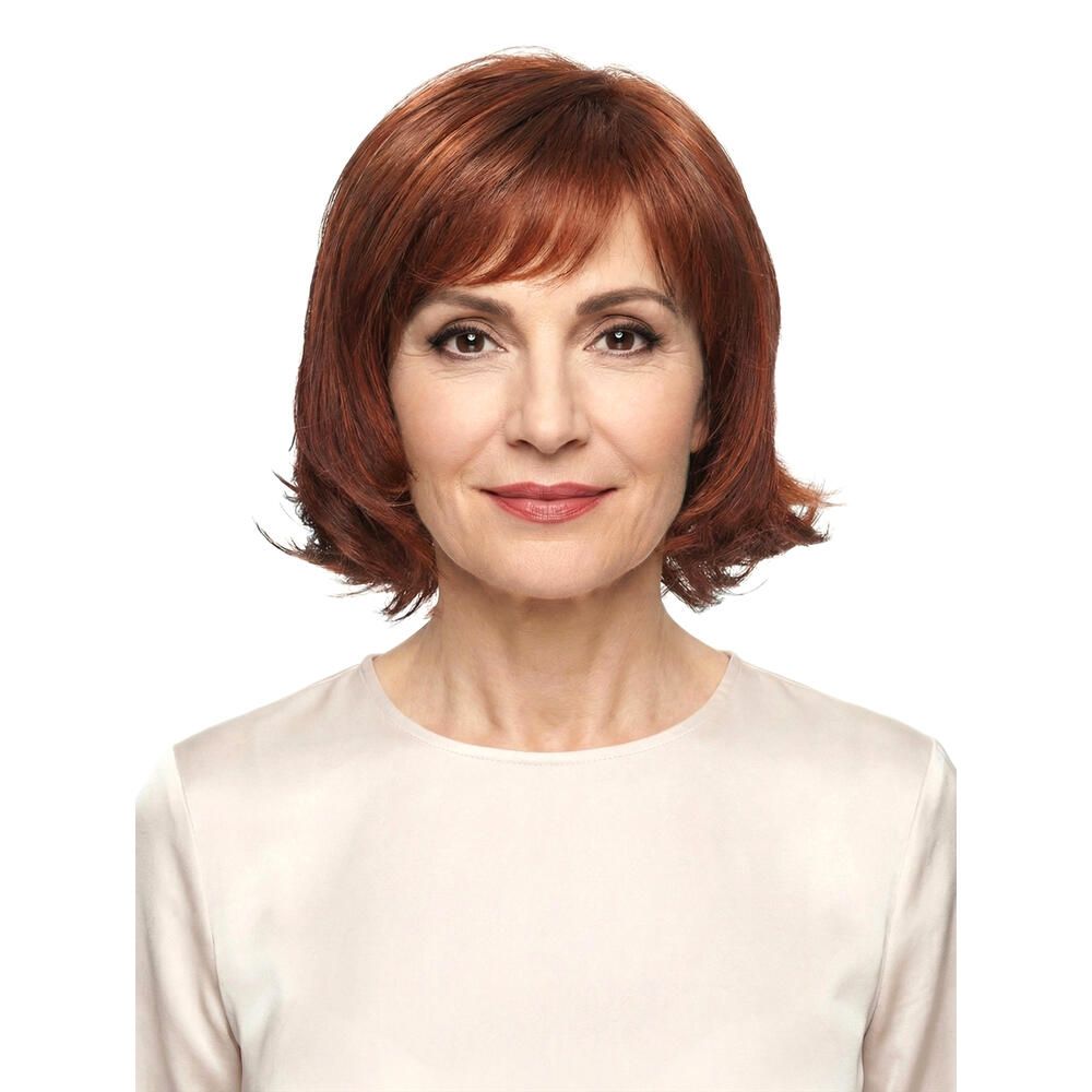 Frau mit roter Perücke MAILAND. Frontansicht. Kurzes, gewelltes Haar mit Pony. Trägt ein cremefarbenes Oberteil.