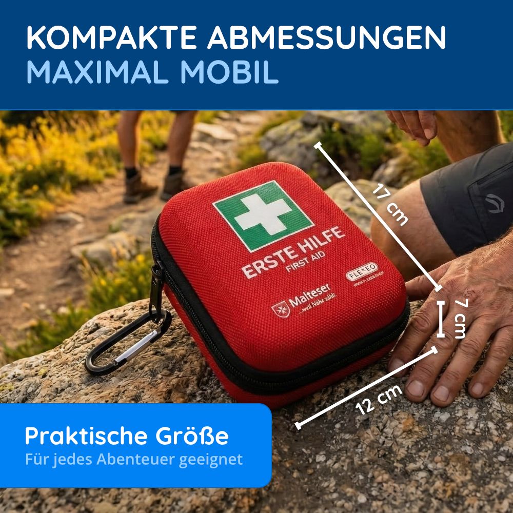 Rotes Erste-Hilfe-Set mit weißem Kreuz. Abmessungen: 17x12x7 cm. Auf einem Stein. Text: Praktische Größe.