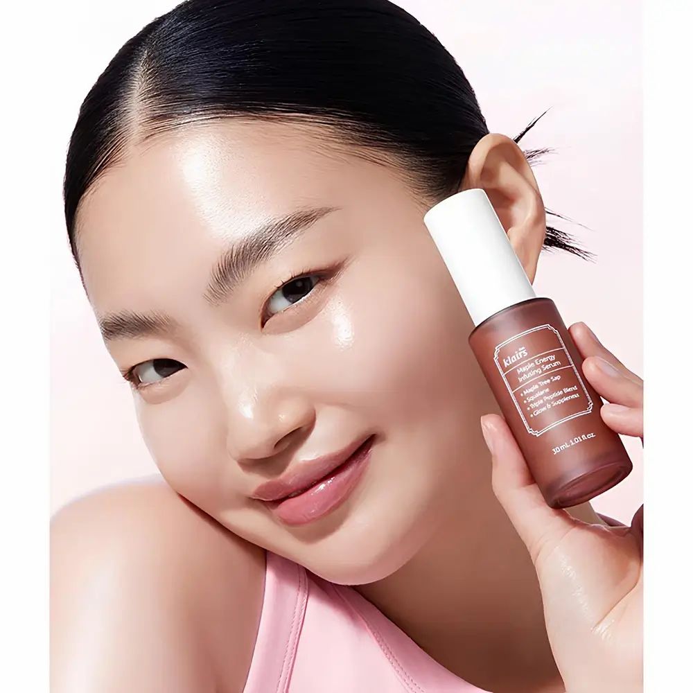 Frau hält Serumflasche. Beschriftung: klairs, Maple Energy Infusing Serum, 30 ml.