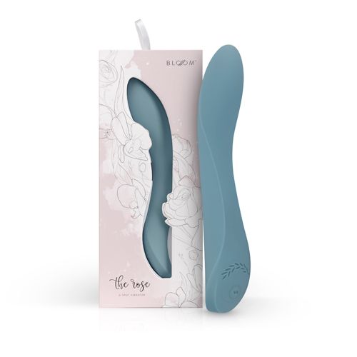 Blaugrüner Vibrator neben Verpackung. Verpackung mit floralem Muster und Produktname "the rose". Marke: BLOOM.