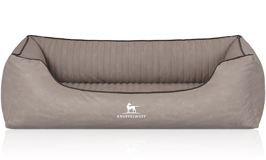 Orthopädisches Hundebett Columbia, beige. Rechteckige Form mit erhöhten Seiten. Schwarze Paspelierung. Knuffelwuff-Logo.