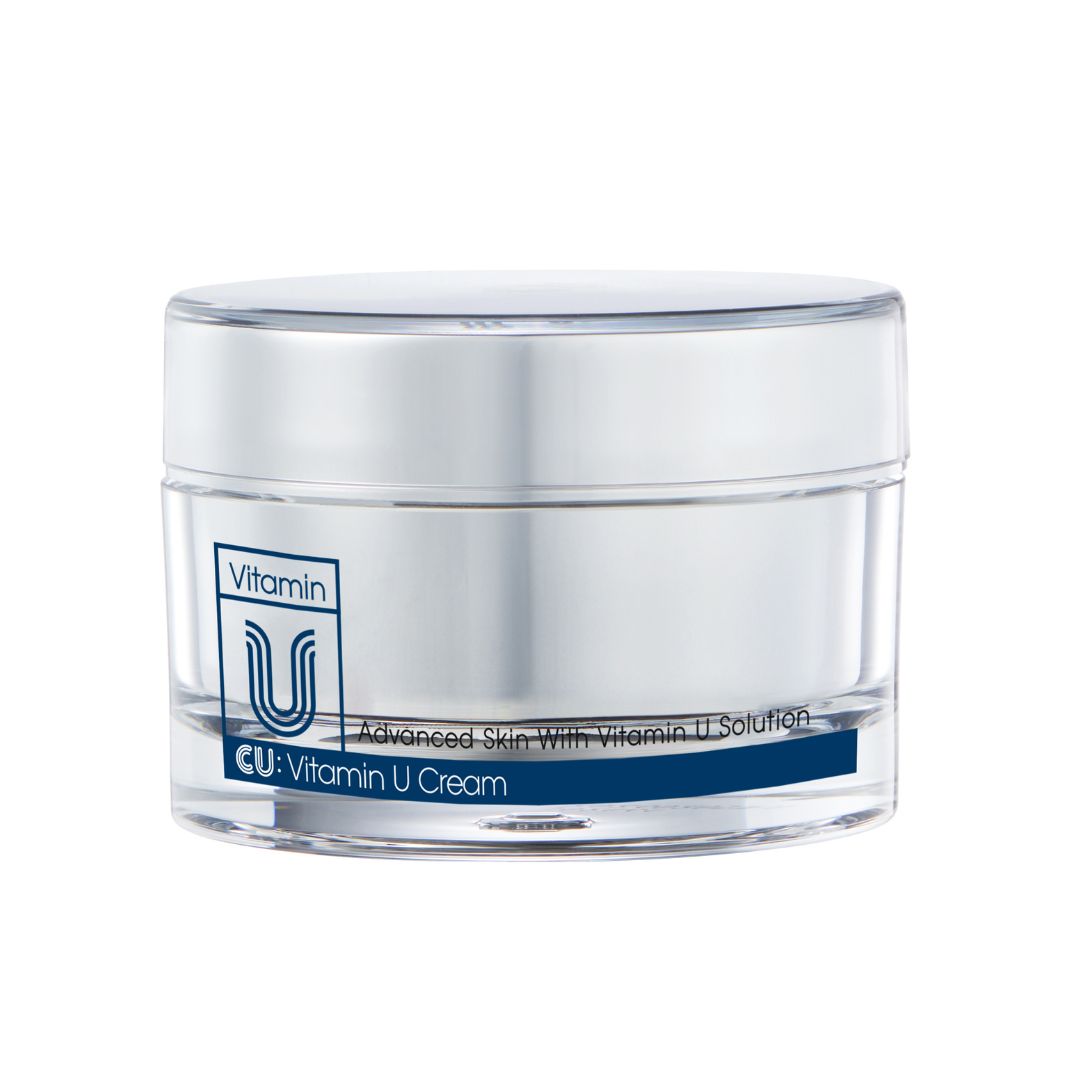 Creme-Glas mit Deckel. Aufschrift "Vitamin U" und "CU: Vitamin U Cream". Blaue Schrift auf weißem Hintergrund.