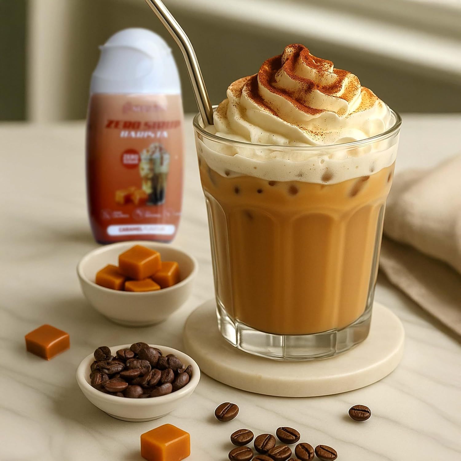 Glas Eiskaffee mit Sahne, daneben Flasche Neosupps Zero Sirup Barista, Karamellbonbons, Kaffeebohnen.