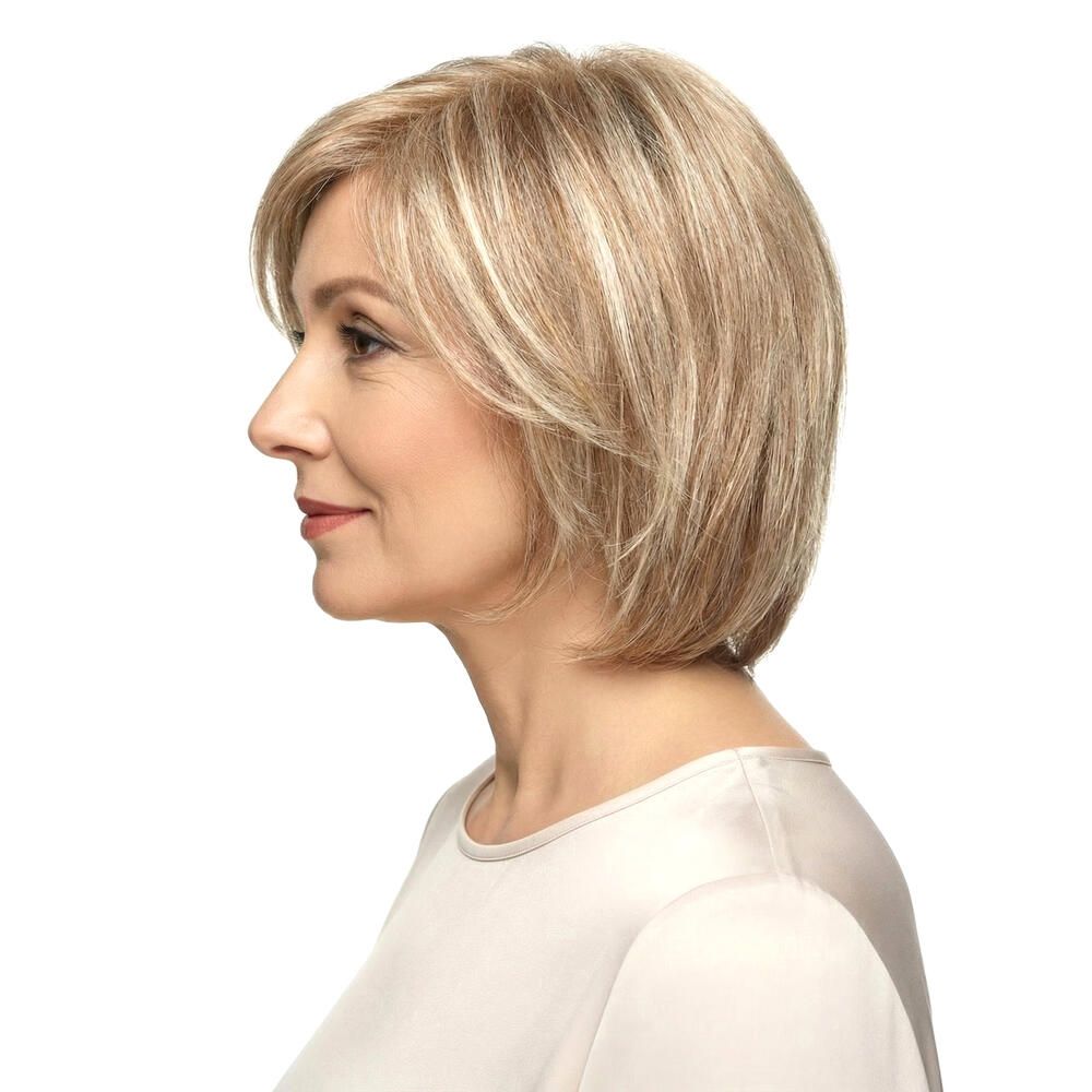 Perücke STOCKHOLM, blond, mittellang, mit Pony. Frau mit Perücke, Seitenansicht, vor weißem Hintergrund.