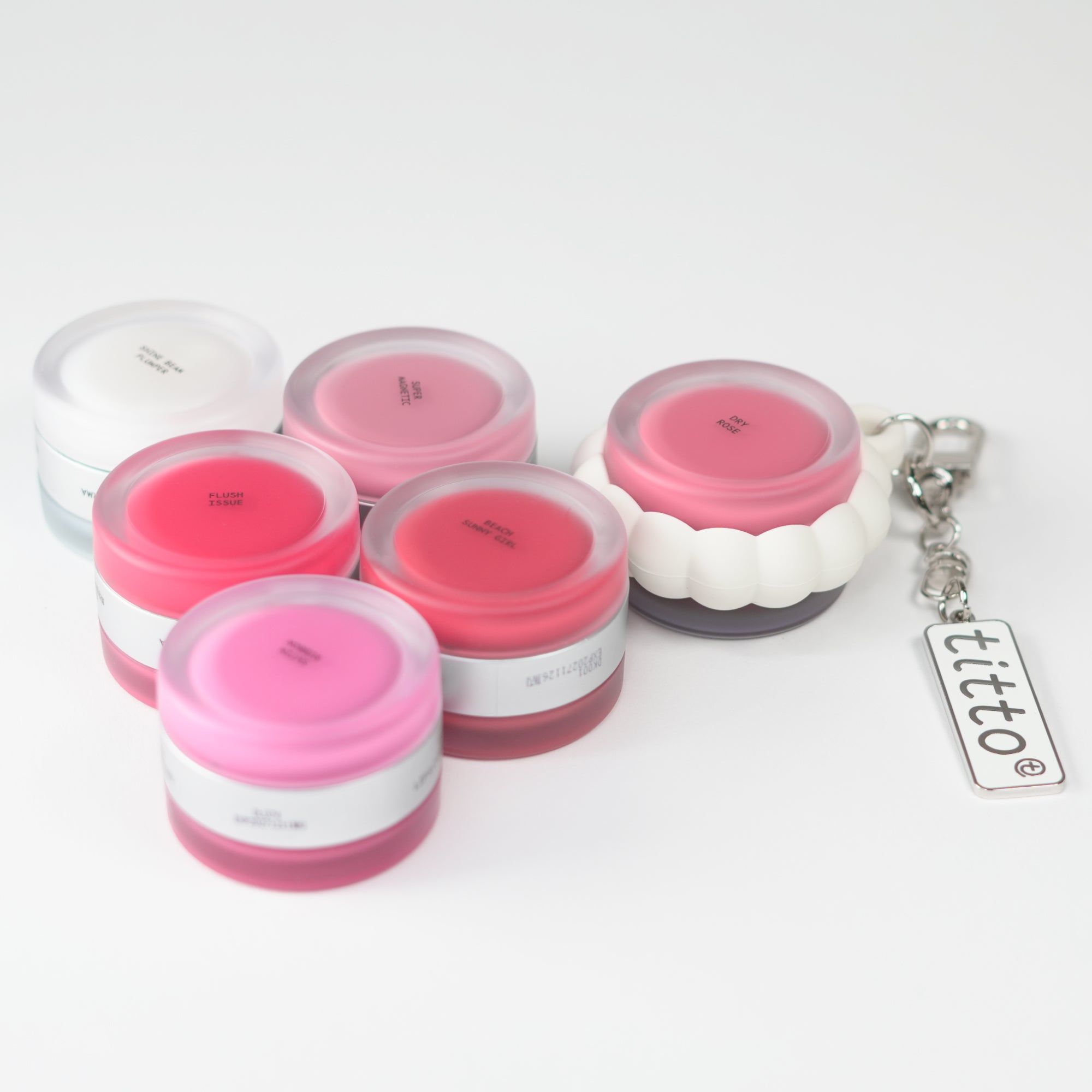 Mehrere Behälter mit Lippen- und Wangenfarbe. Sie sind mit einem Schlüsselanhänger versehen.