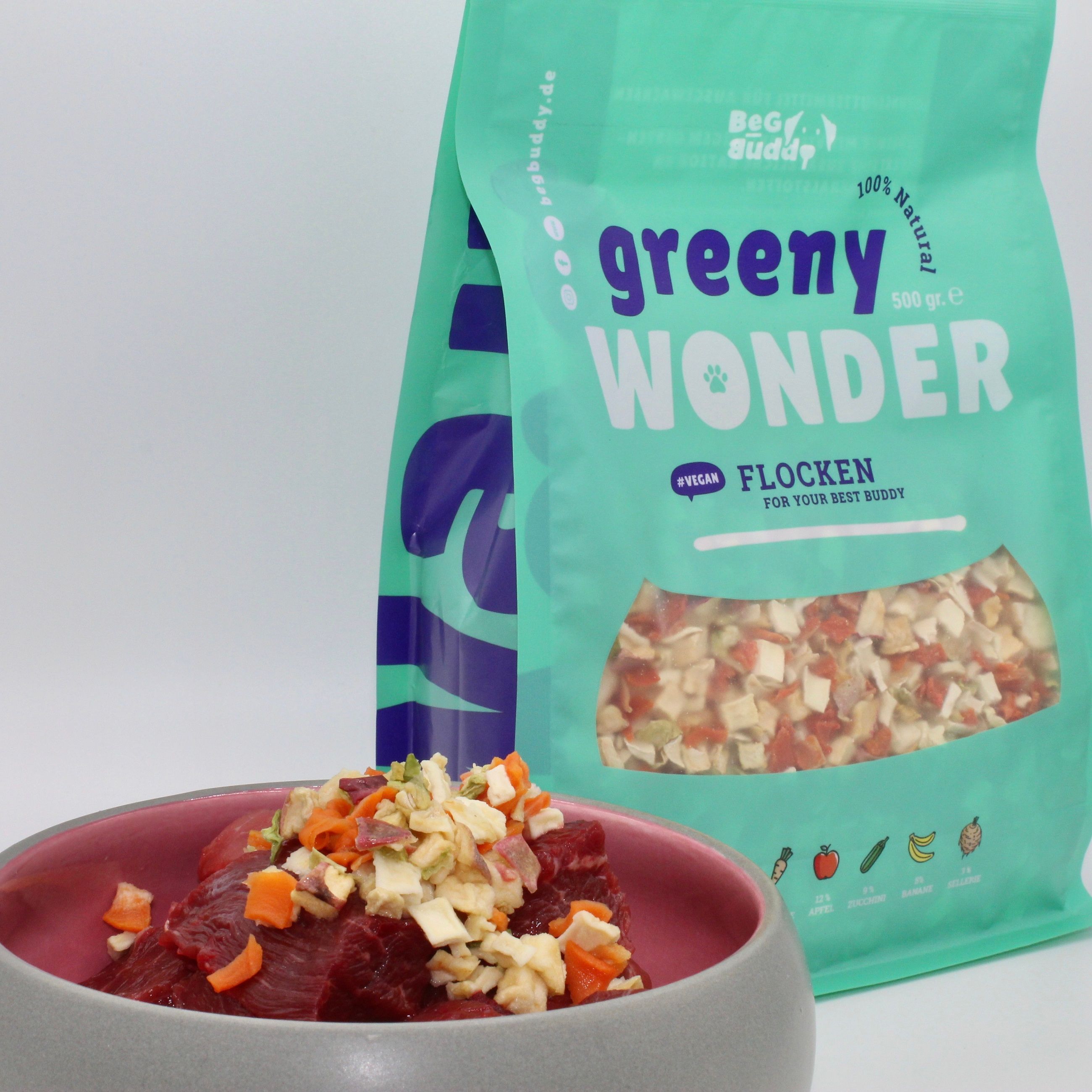 Schüssel mit Fleisch und Gemüse neben einem Beutel Greeny Wonder Flocken.